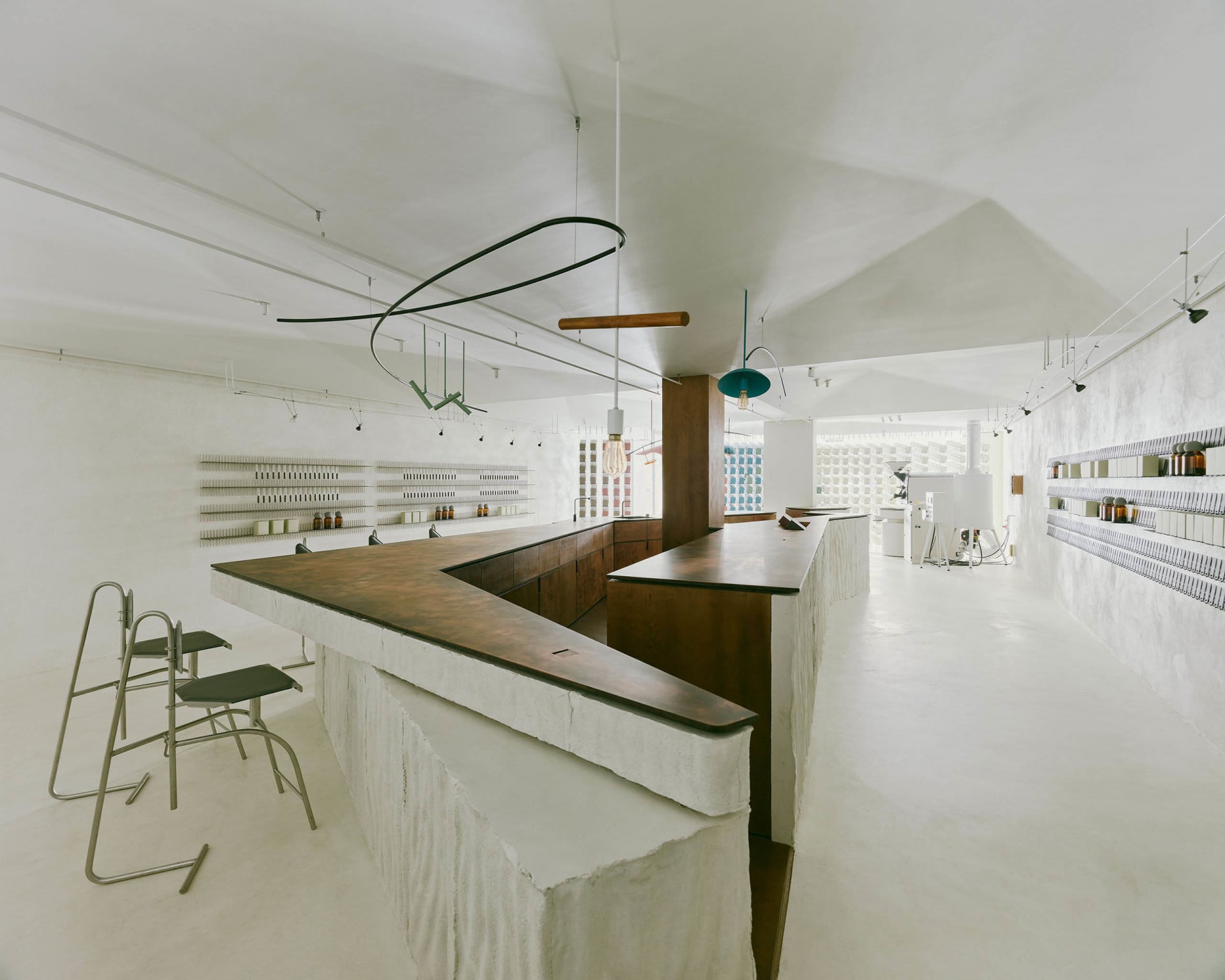 Open kitchen area with a bar counter, chairs, sink, and bottles, with a clean and well-organized atmosphere