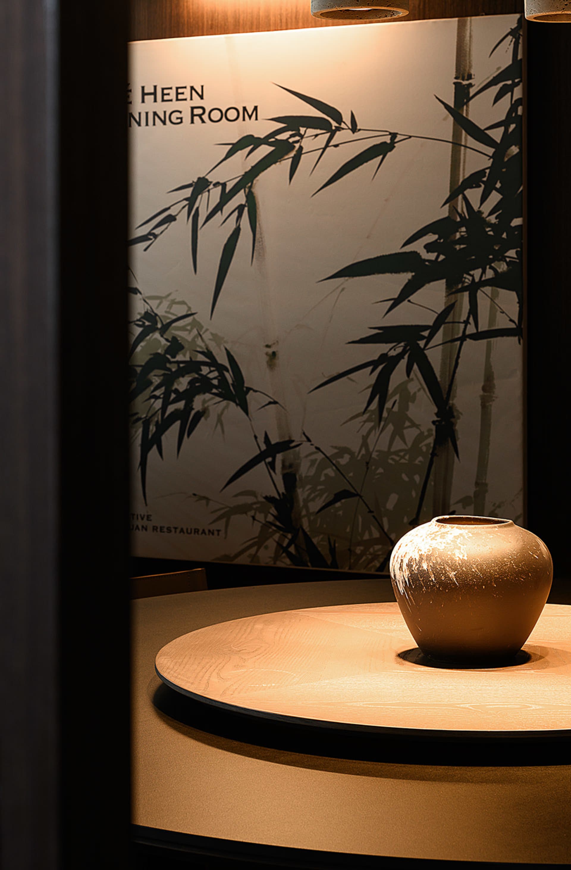 A warm and inviting oriental restaurant interior with a wooden dining table, Asian artwork, and bamboo elements