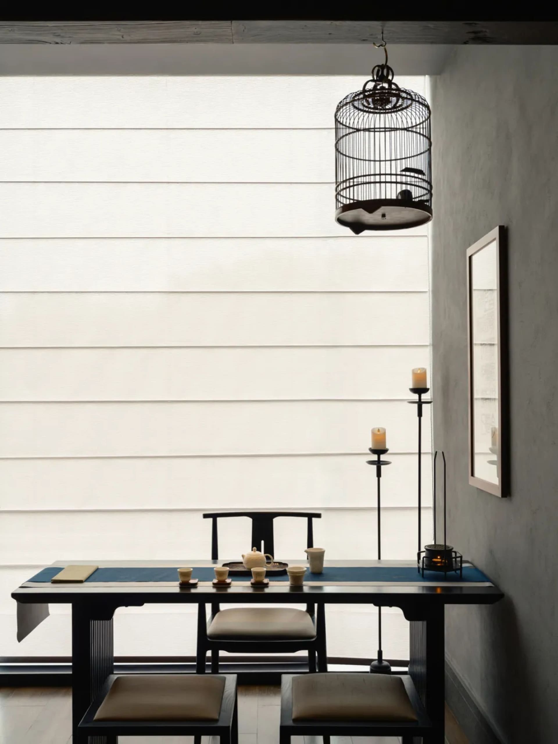 A modern office space with a desk and dining table, featuring a chair, cups, and bowls, with a neutral background