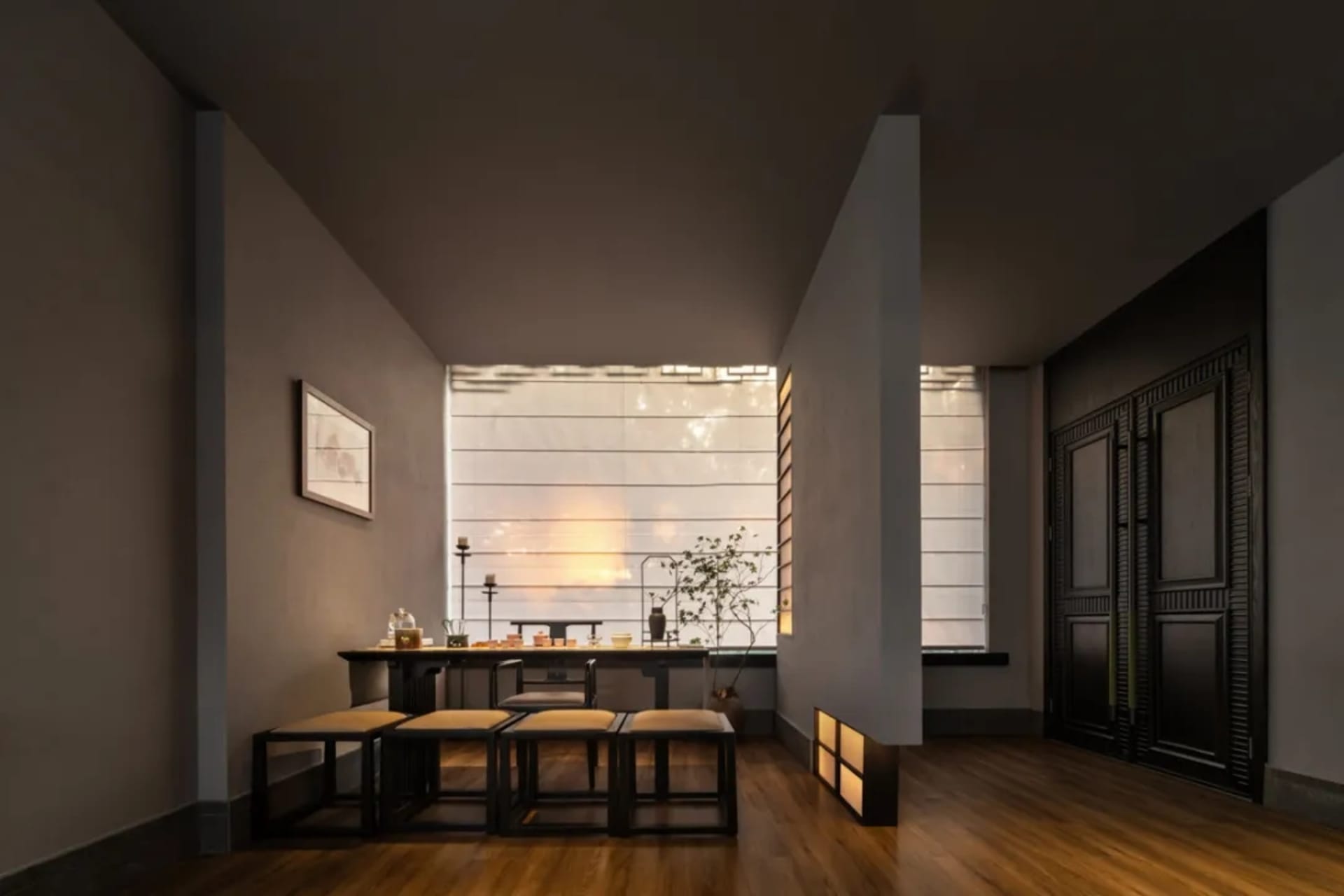 Empty modern living room with a dining table, chairs, potted plants, and decorative bottles, creating a cozy atmosphere