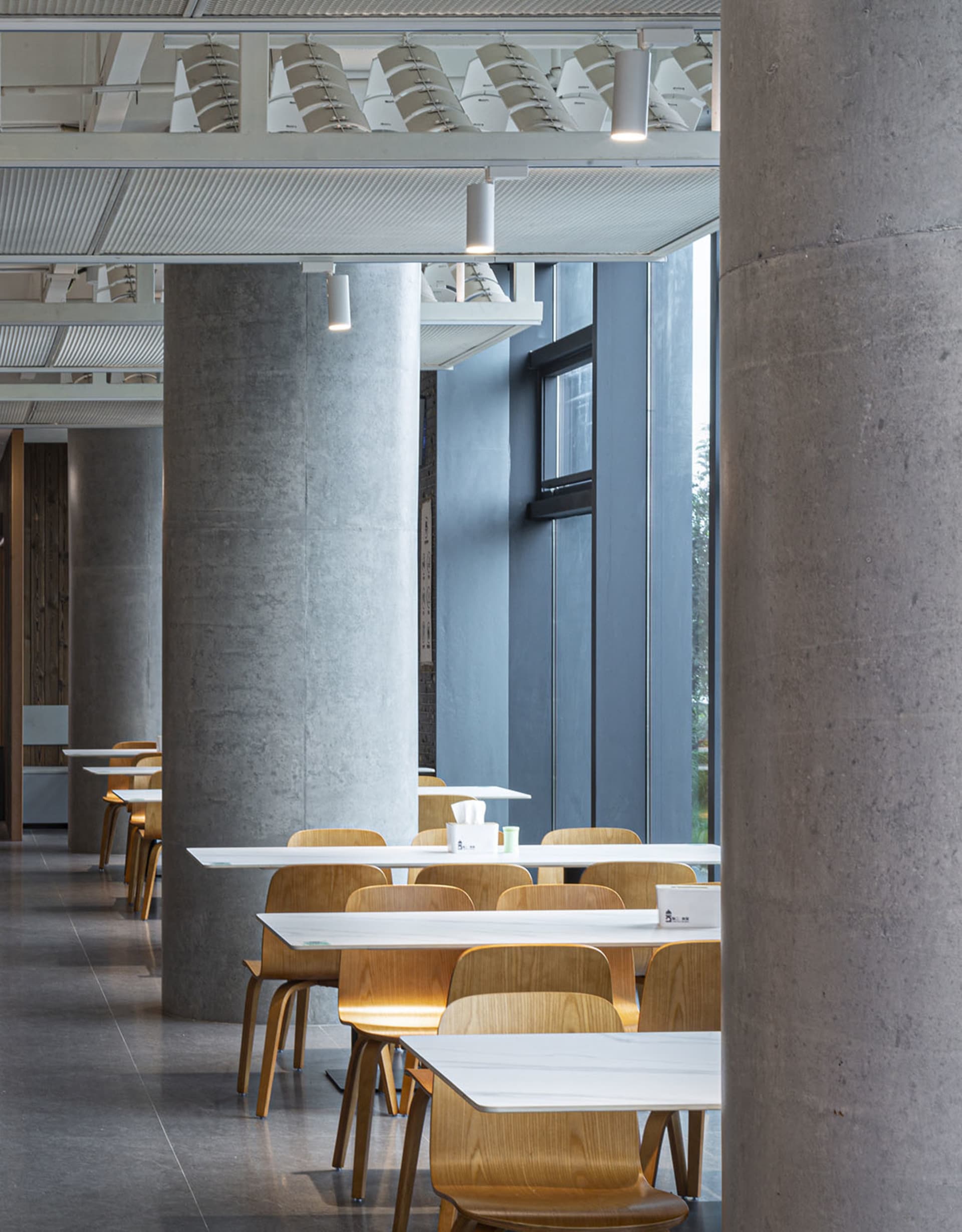 現代餐廳區域，配有多張白色餐桌與椅子、杯具，以及寬敞氛圍