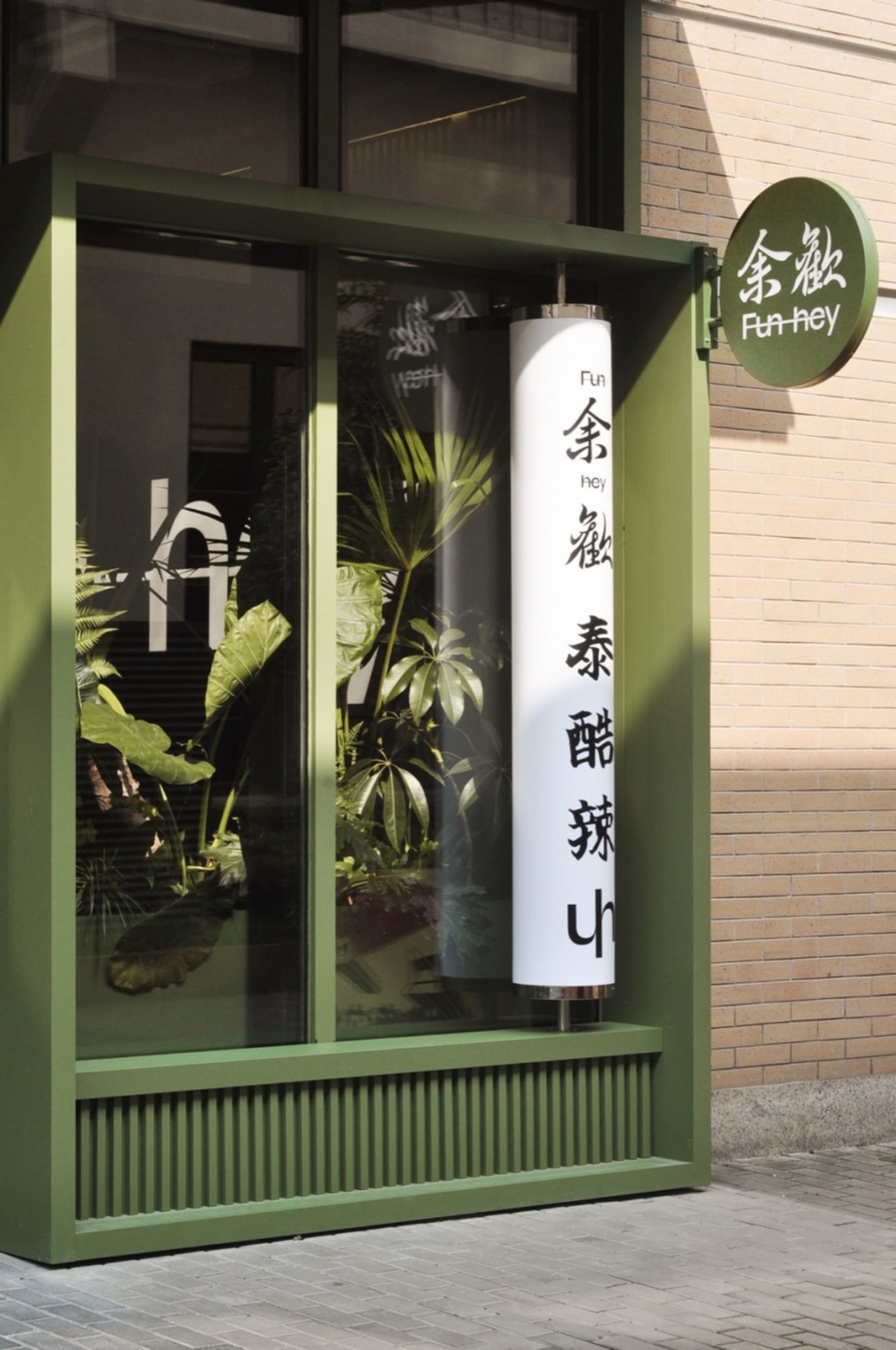 A small store with green walls and a window display filled with various plants, adding to the lush atmosphere