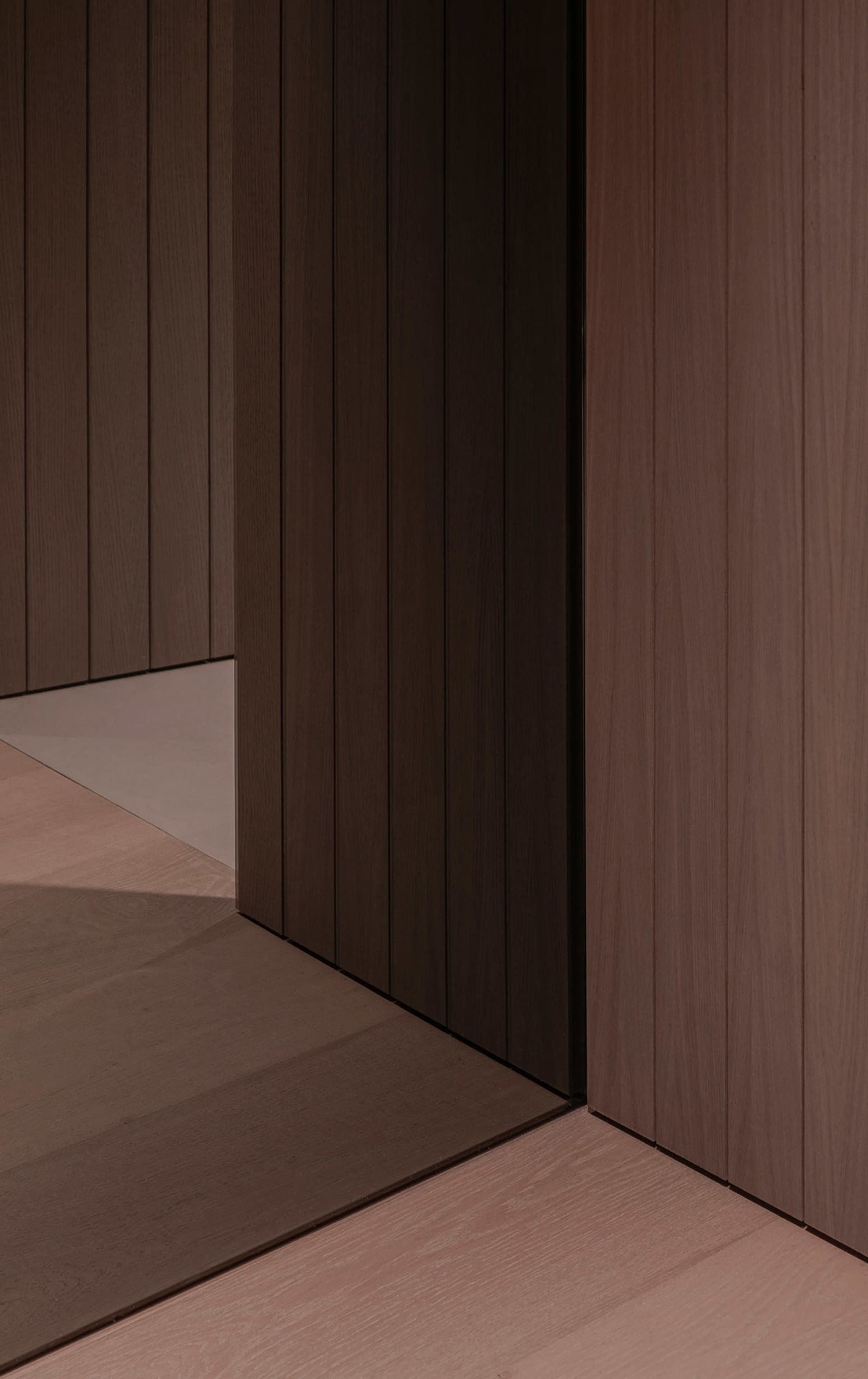 A darkened hallway with a classic wooden doorway, contrasting with the brightness of the doorway