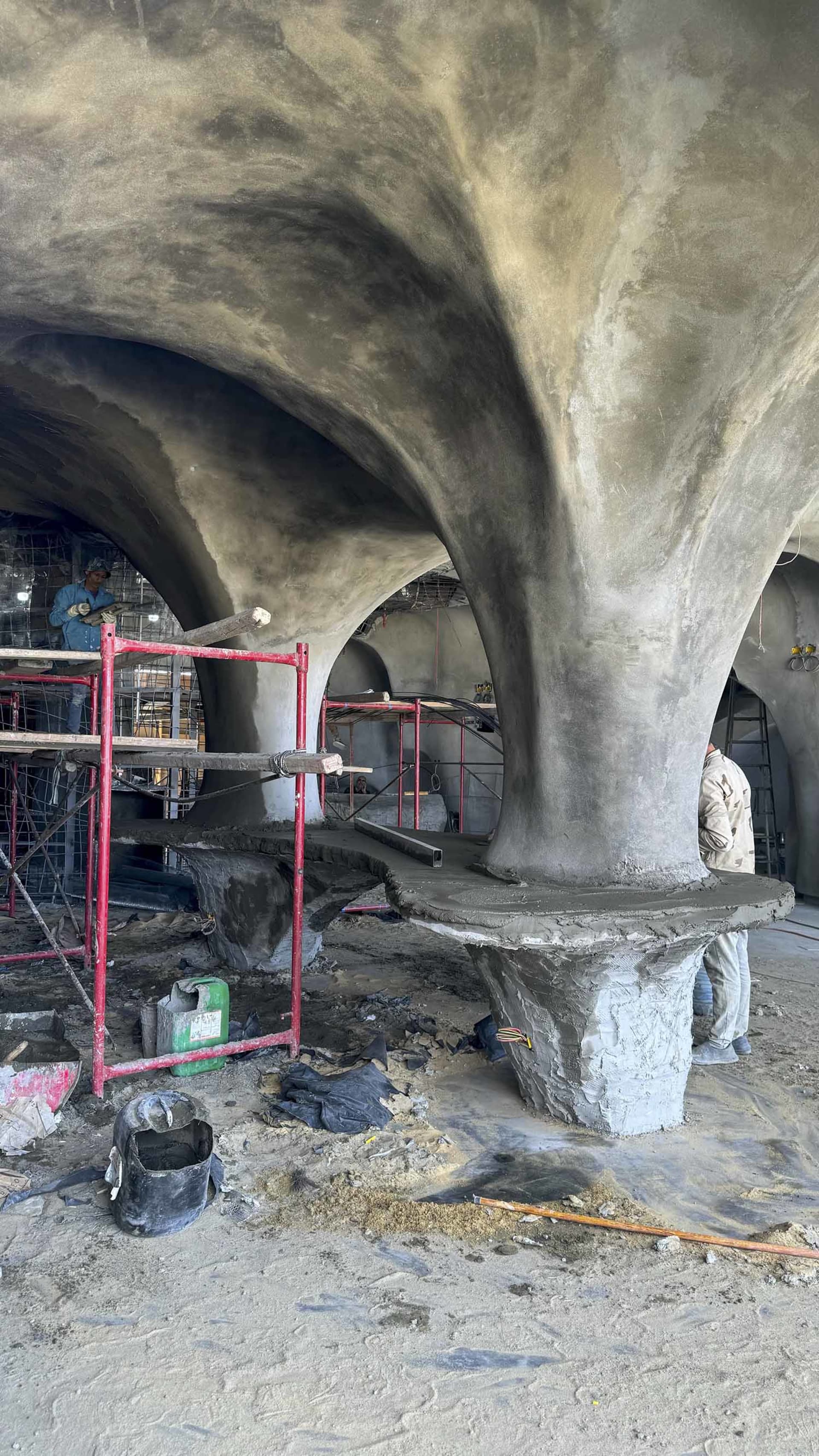 Construction site with a stone archway, workers, tools, and a collaborative atmosphere