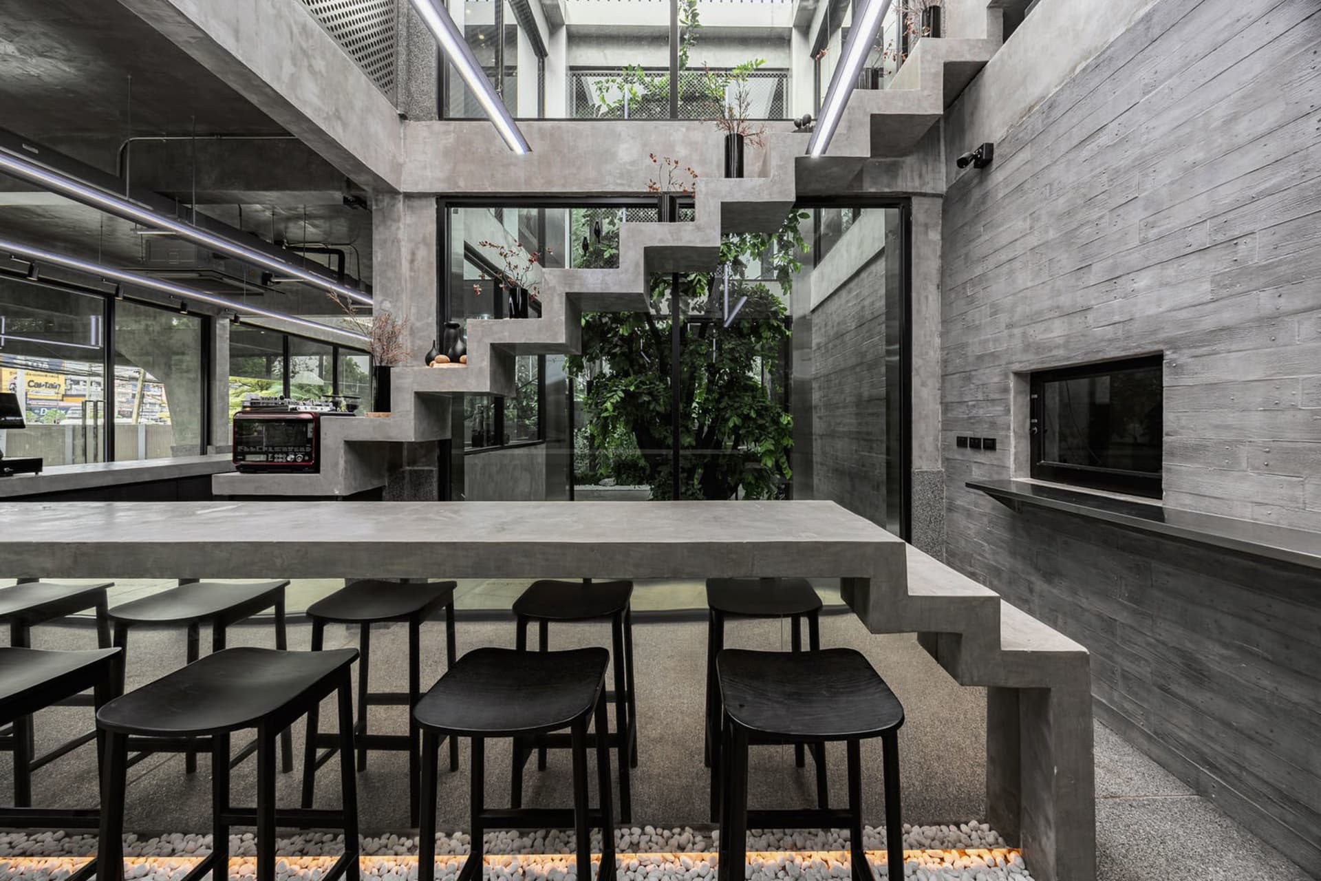 A modern open-plan space with a staircase, chairs, and well-lit atmosphere