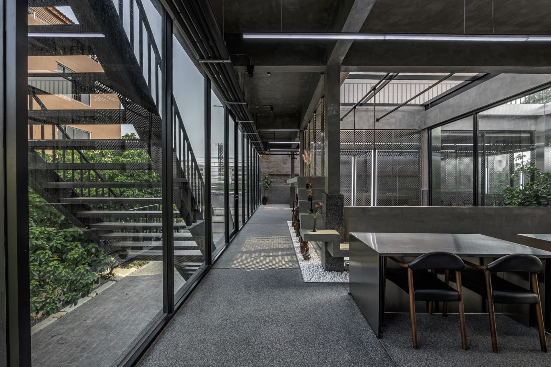 Bright and inviting office space with grey walls, a large window, and a dining table, featuring two chairs and natural light