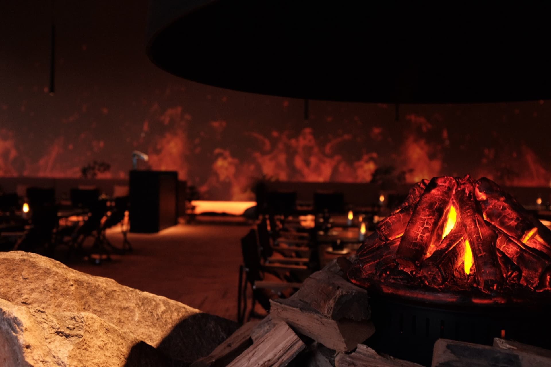 Cozy restaurant interior with a wood fireplace, stone mantle, and comfortable seating area