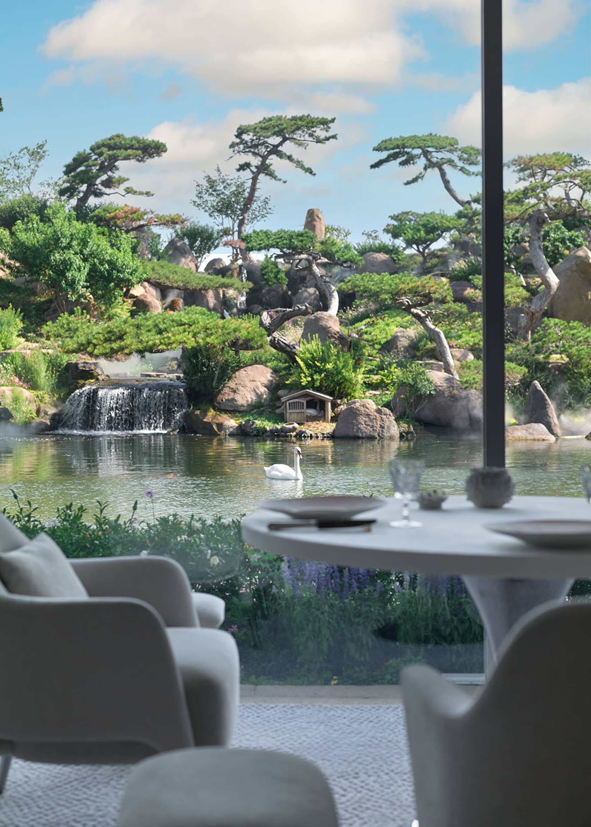 Elegant dining room with a table set for a meal, two chairs, and a vase, overlooking a beautiful garden through a large window