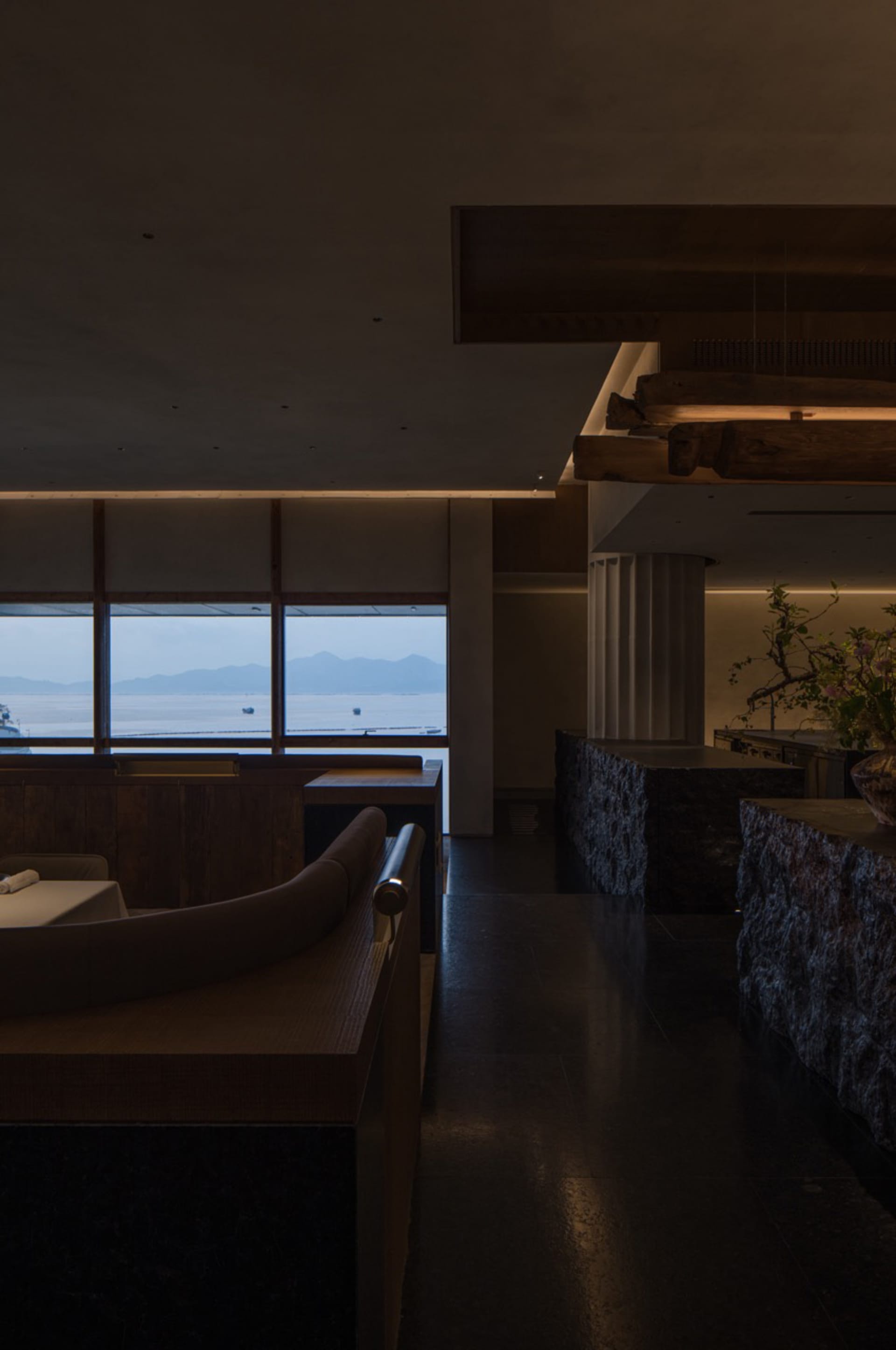 Coastal dining space with a large window offering ocean views, comfortable seating, and a bar area