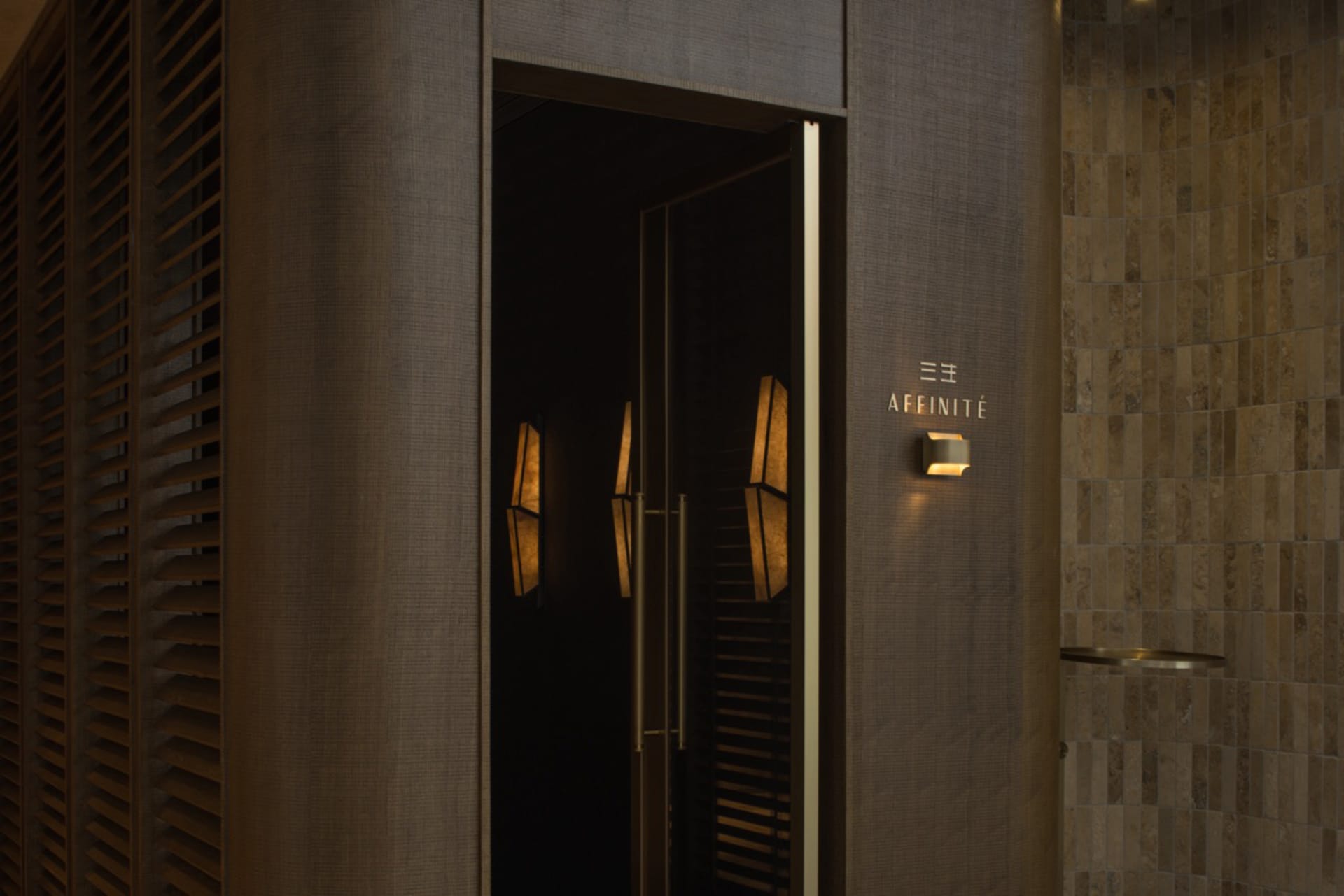 A doorway with a brown wooden frame and gold trim, illuminated by two lights on either side