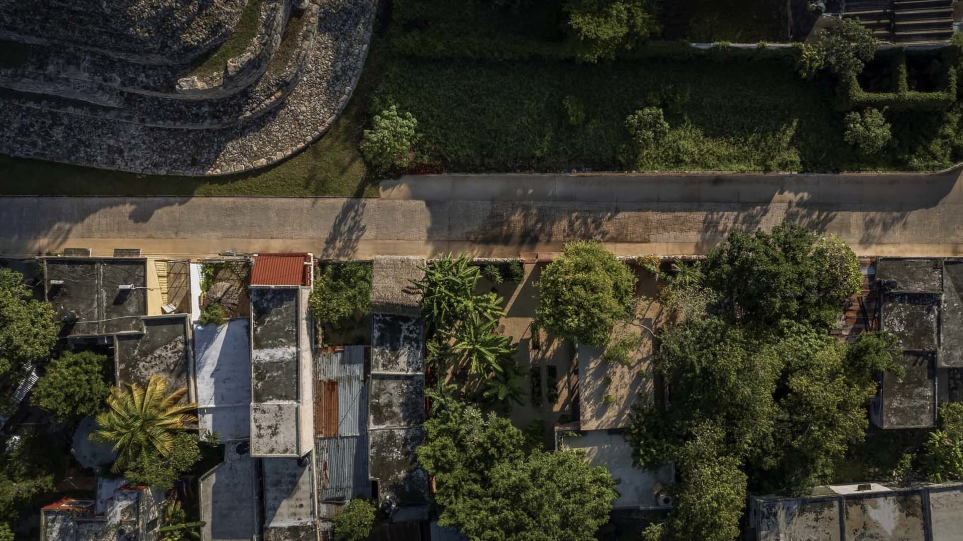 Aerial view of a residential area with multiple buildings of different heights and styles surrounded by trees, featuring balconies and a sense of community