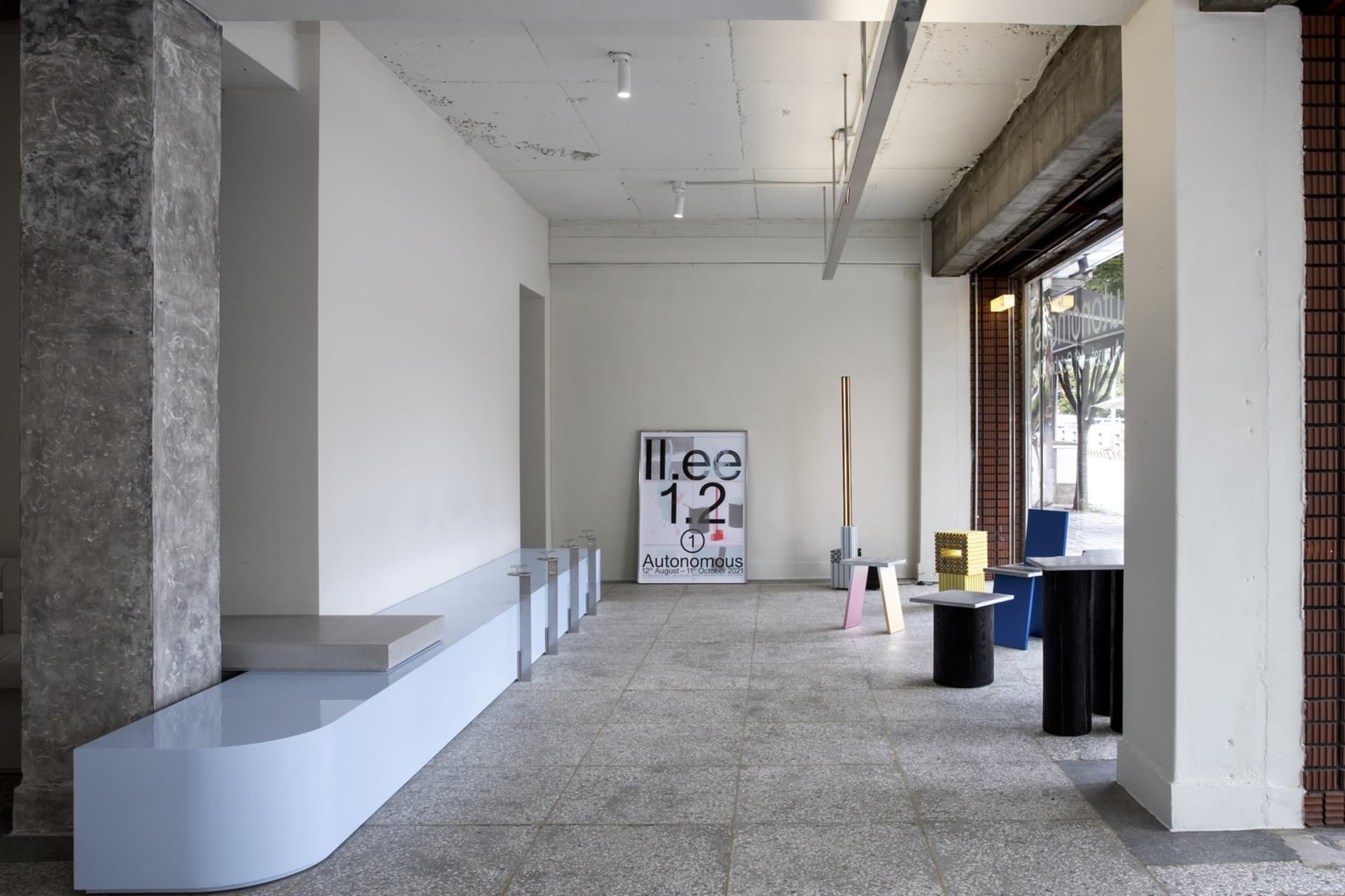 Empty industrial space with a concrete floor, featuring benches, chairs, and dining tables in a minimalist and clean atmosphere