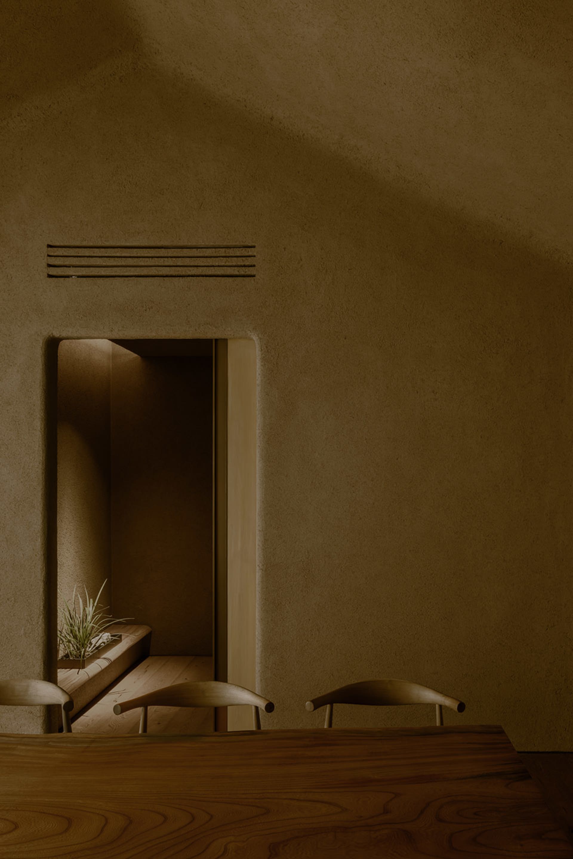 Empty room with stone walls, a doorway, and three chairs creating a welcoming atmosphere