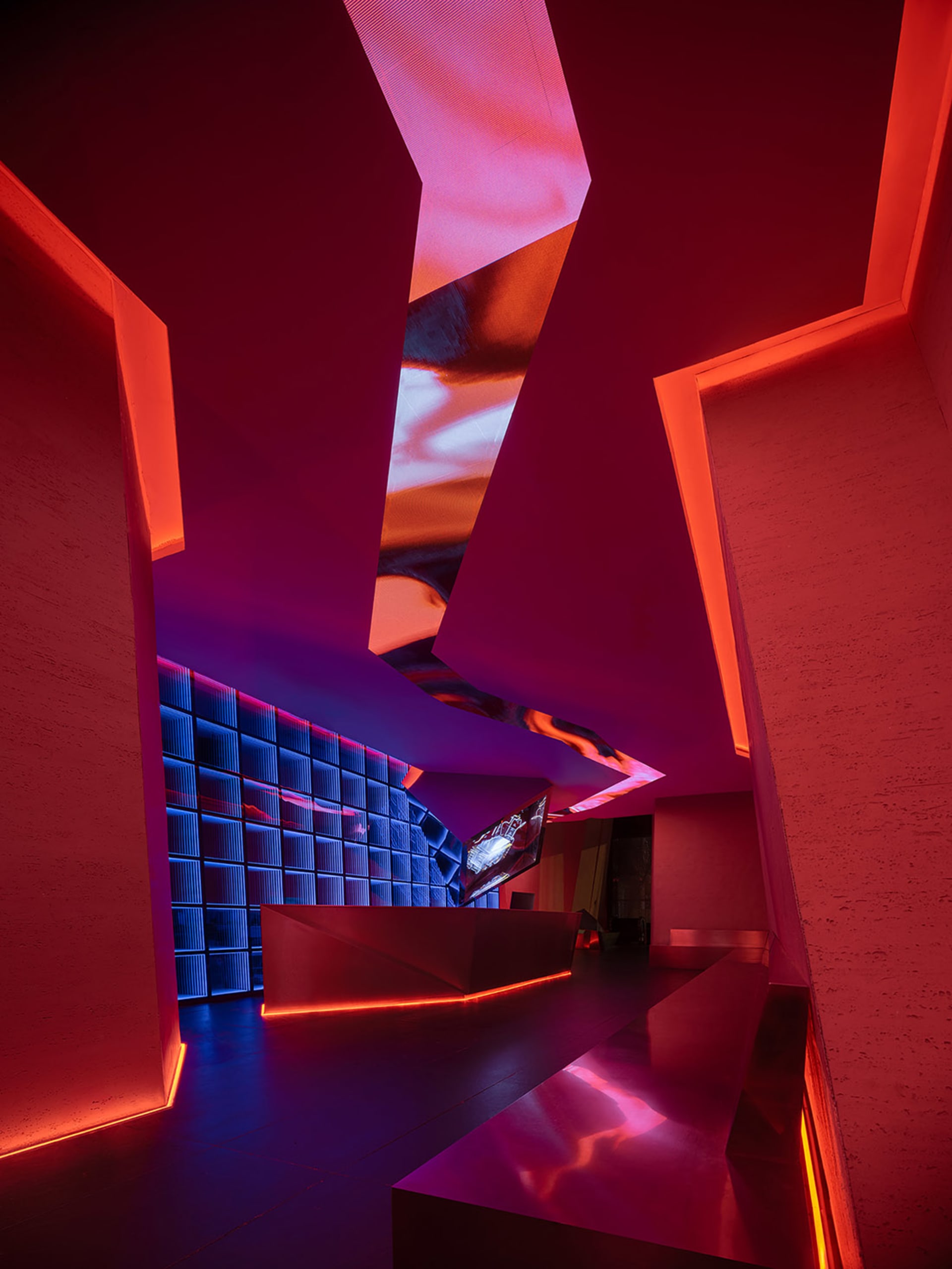 Interior design with bright red lights, white surfaces, a large TV, and sleek furniture in a modern and futuristic setting