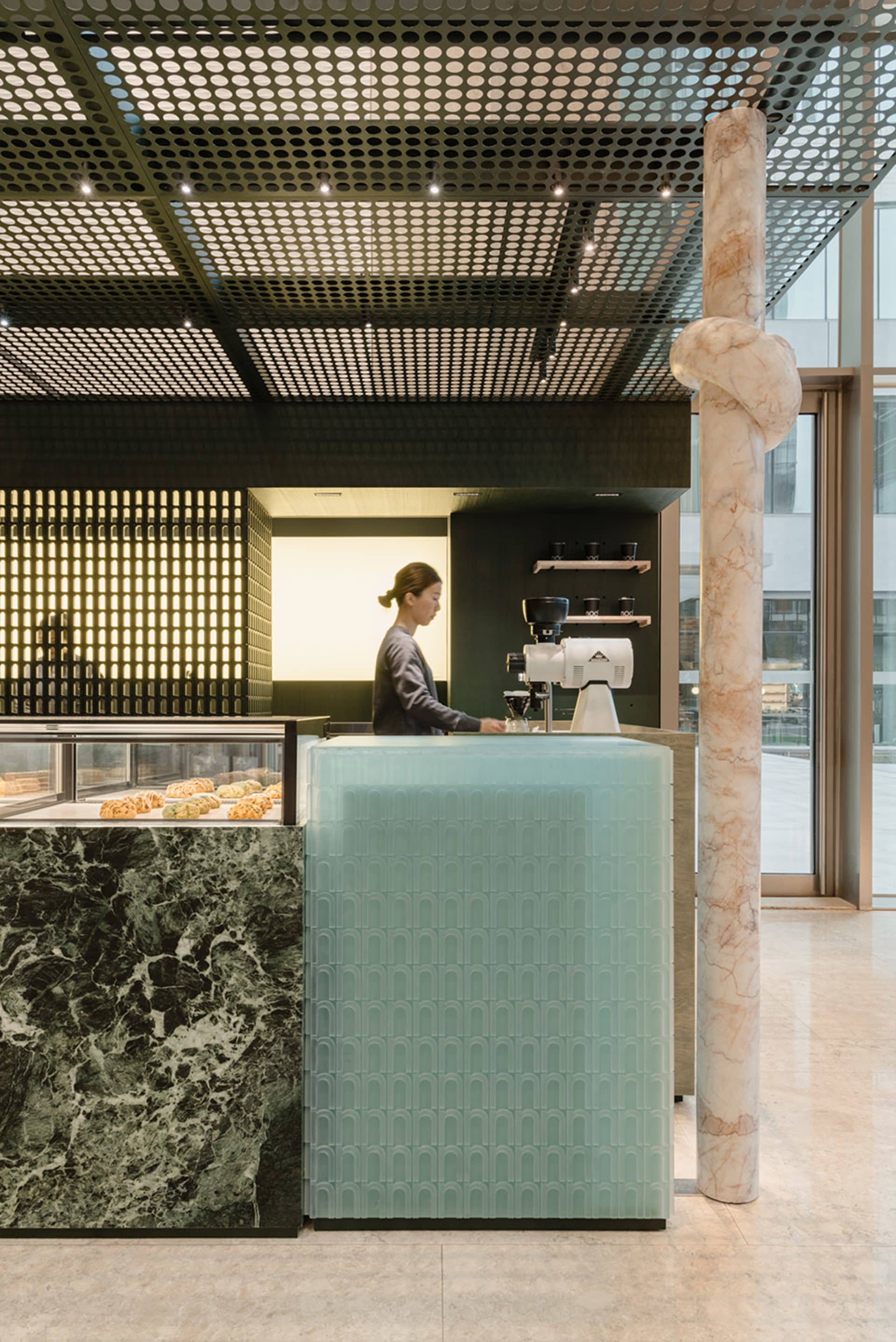A welcoming restaurant counter with a marble surface, serving food and drinks, with donuts on display