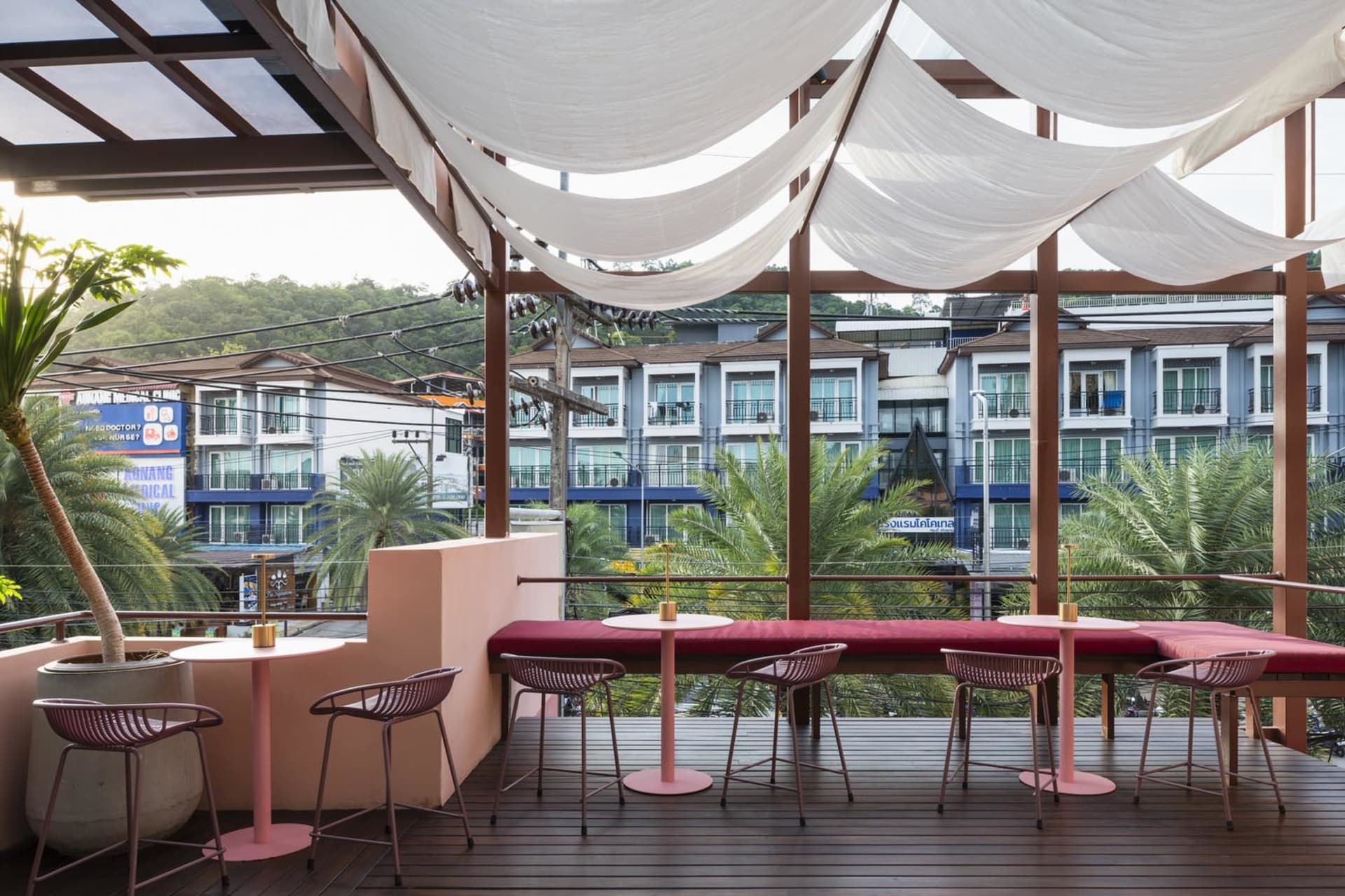 Inviting outdoor dining space with a pink table and multiple chairs, surrounded by a comfortable ambiance