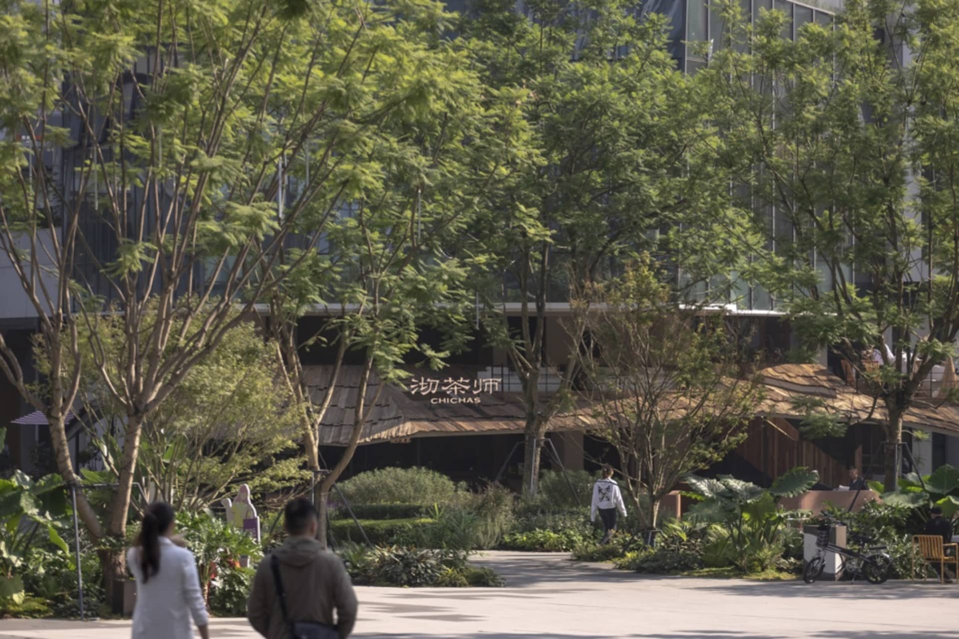 熱鬧的亞洲餐廳，設有餐廳區及多張桌椅，周圍有行人走動