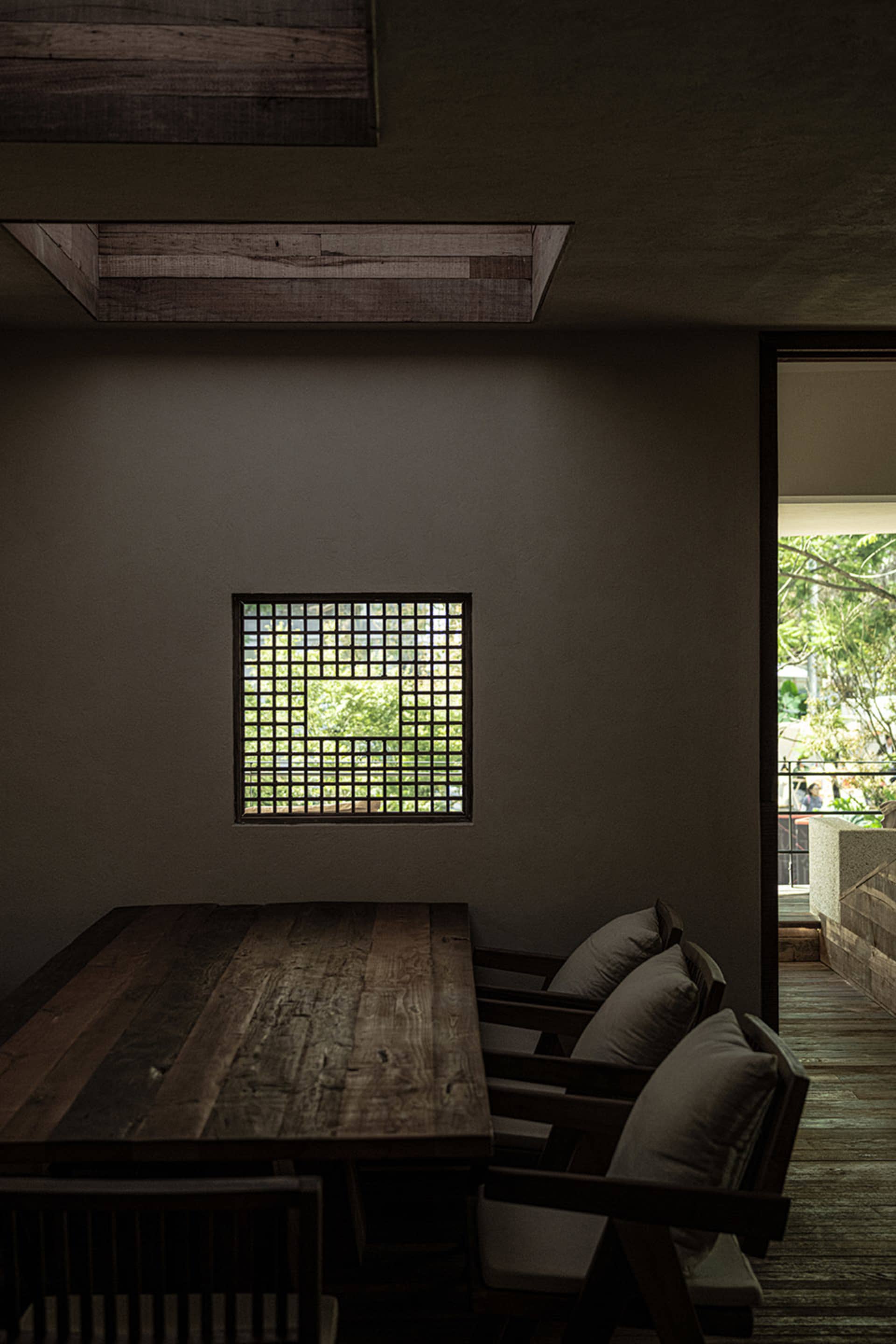 A cozy dining space with a table surrounded by three chairs, each with cushions, creating a warm and inviting atmosphere
