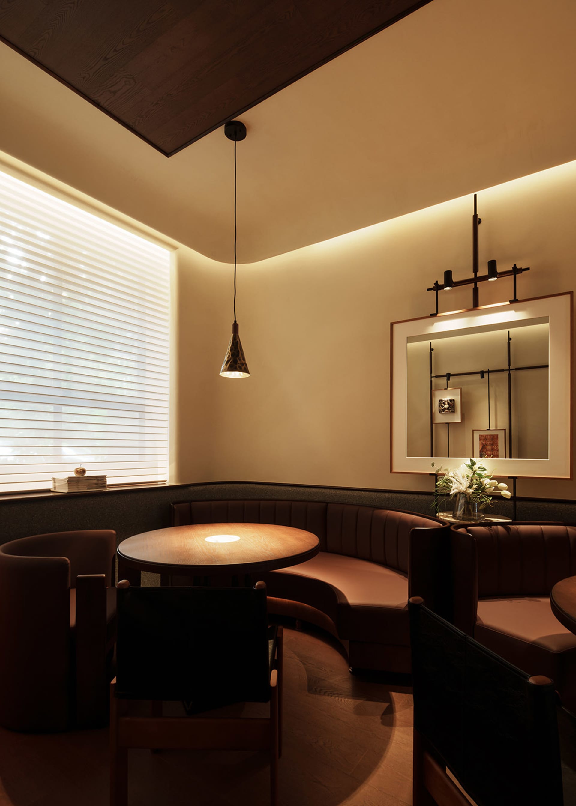 Warm and inviting dining space with brown leather chairs and tables, dimly lit for a cozy ambiance
