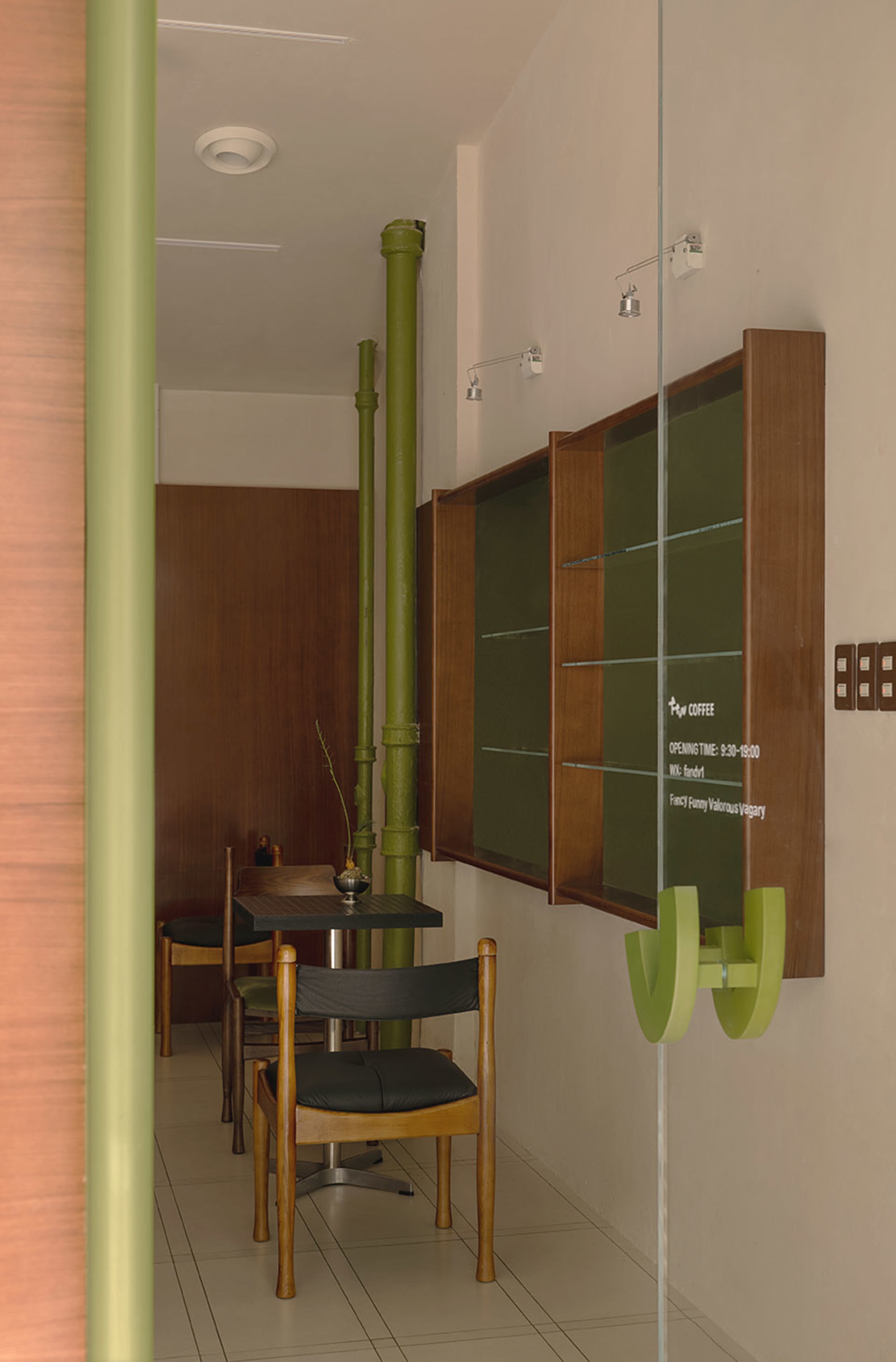 Cozy dining area with green walls, a large table, and two smaller tables, featuring three chairs and a warm atmosphere
