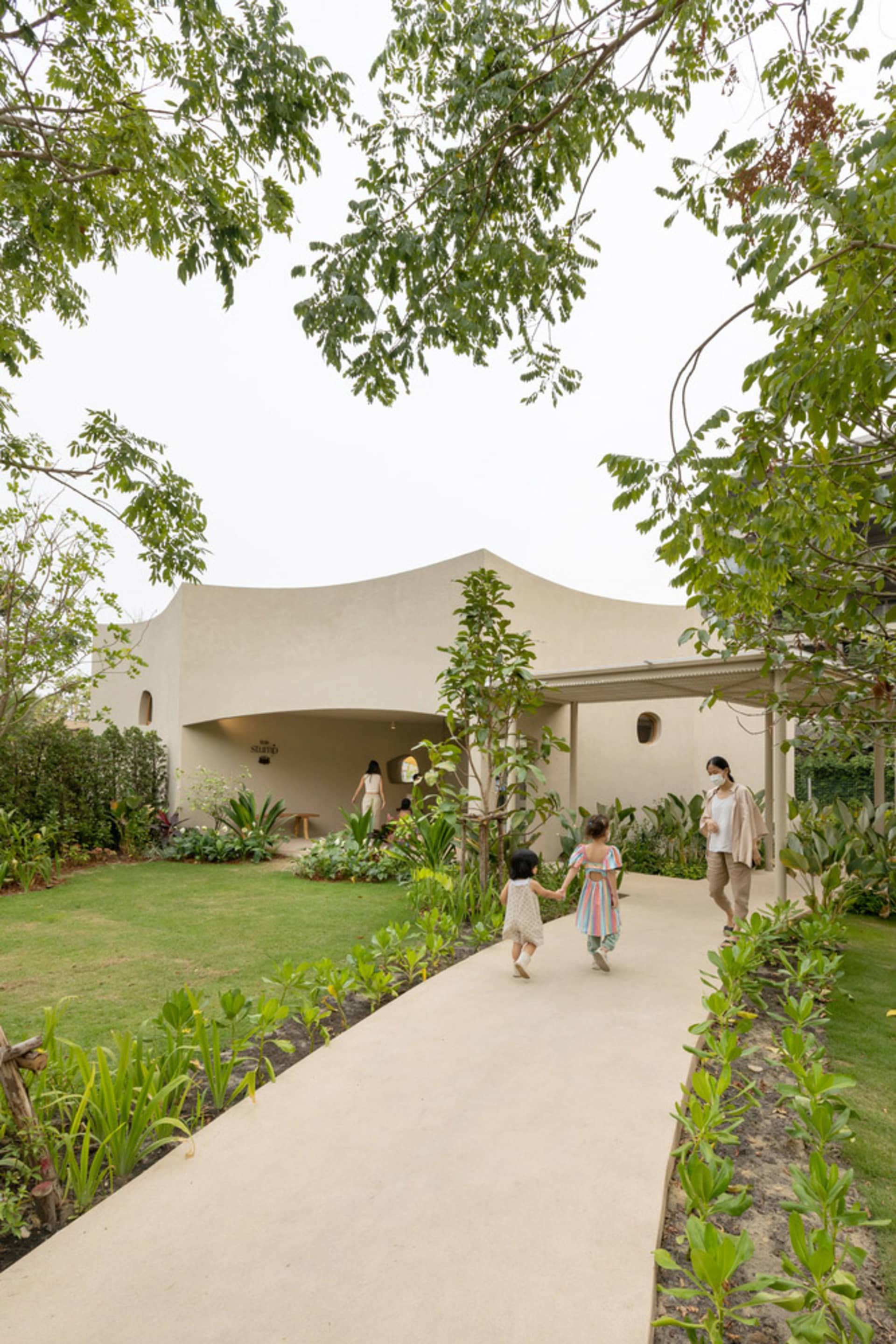 A family enjoys a relaxed outdoor gathering on a patio with a white building in the background