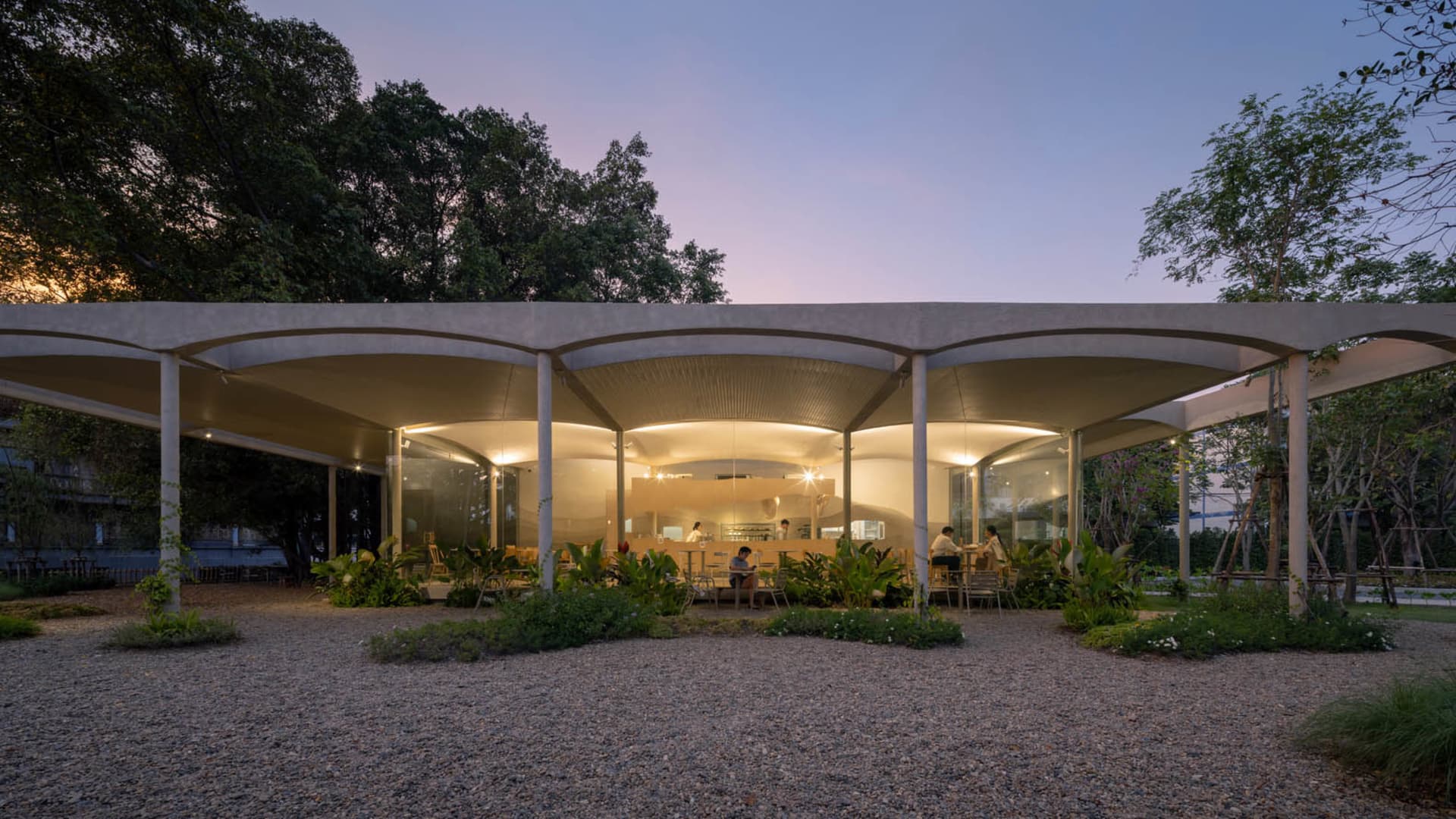 寬敞的戶外餐廳區域，配備現代椅桌，周圍人們在溫馨氛圍中享用餐點