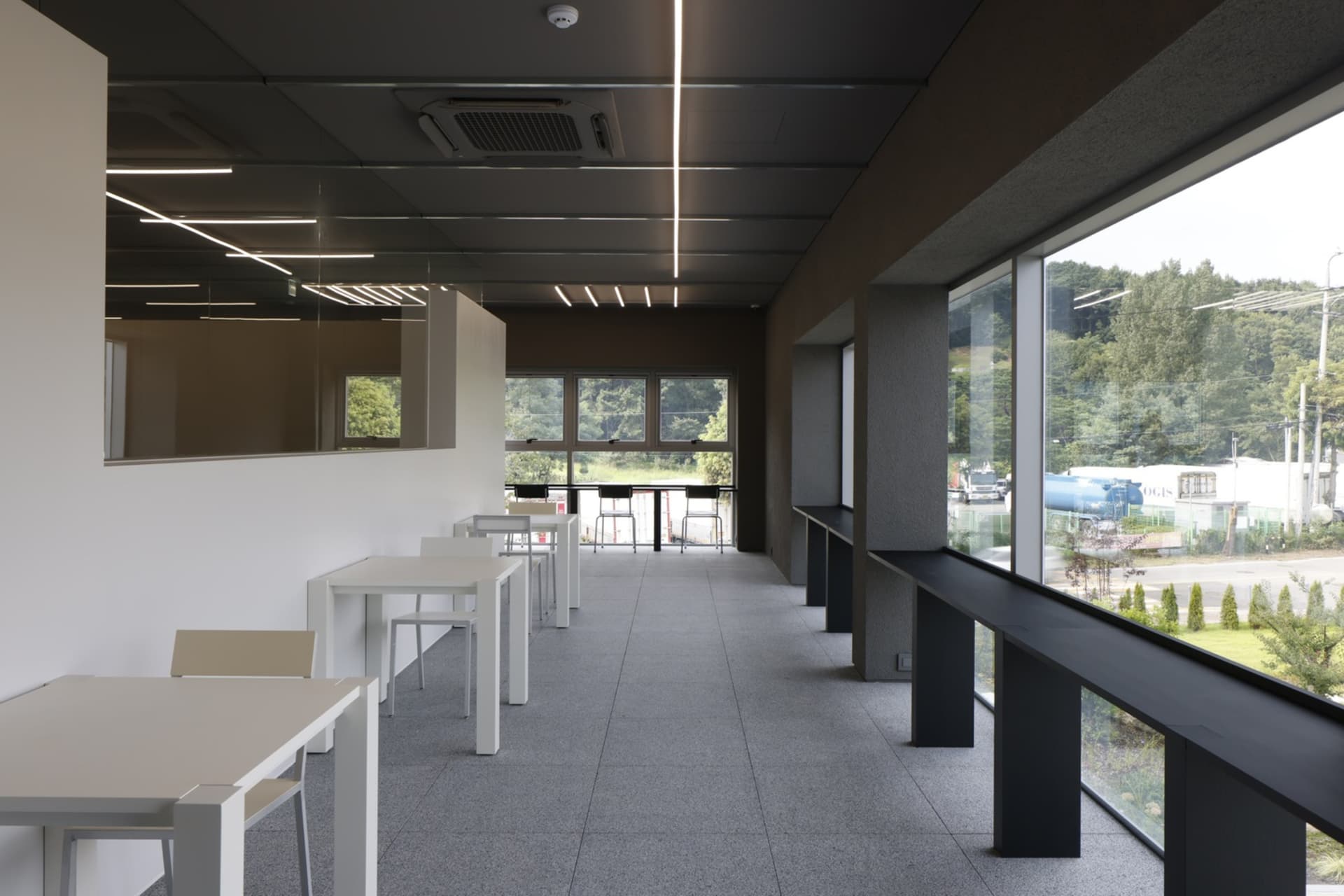 A restaurant dining area with a large white table surrounded by black chairs, creating a comfortable seating arrangement for guests