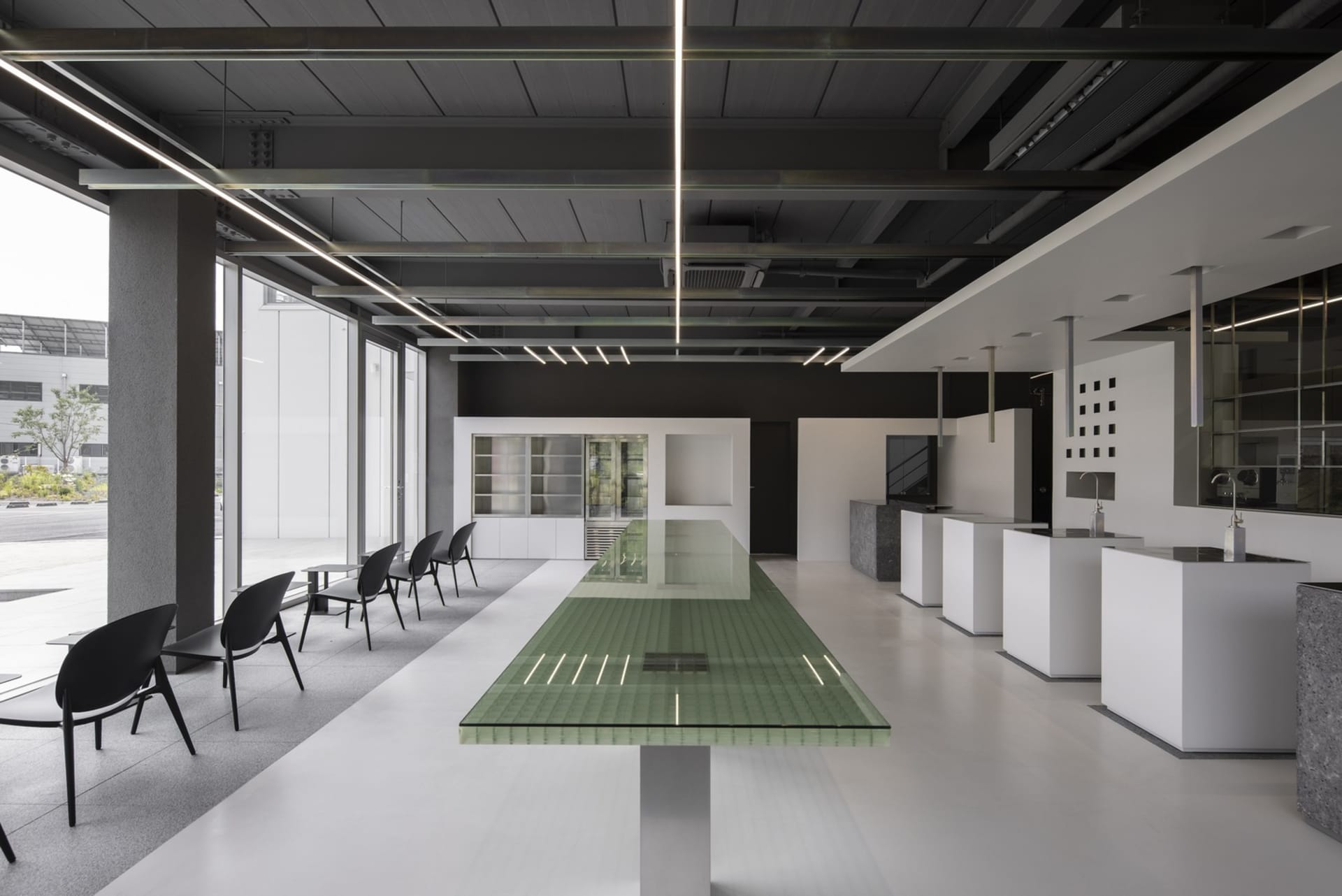 Modern open concept kitchen and dining area with a glass-topped island, white tile flooring, and sleek furniture