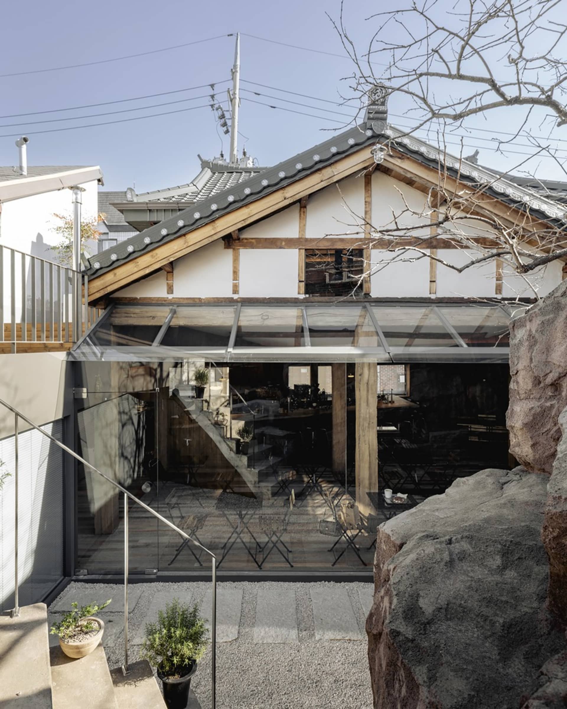 溫暖舒適的空間，擁有木構結構、斜屋頂，以及寬敞開放區域，配有餐桌與盆栽