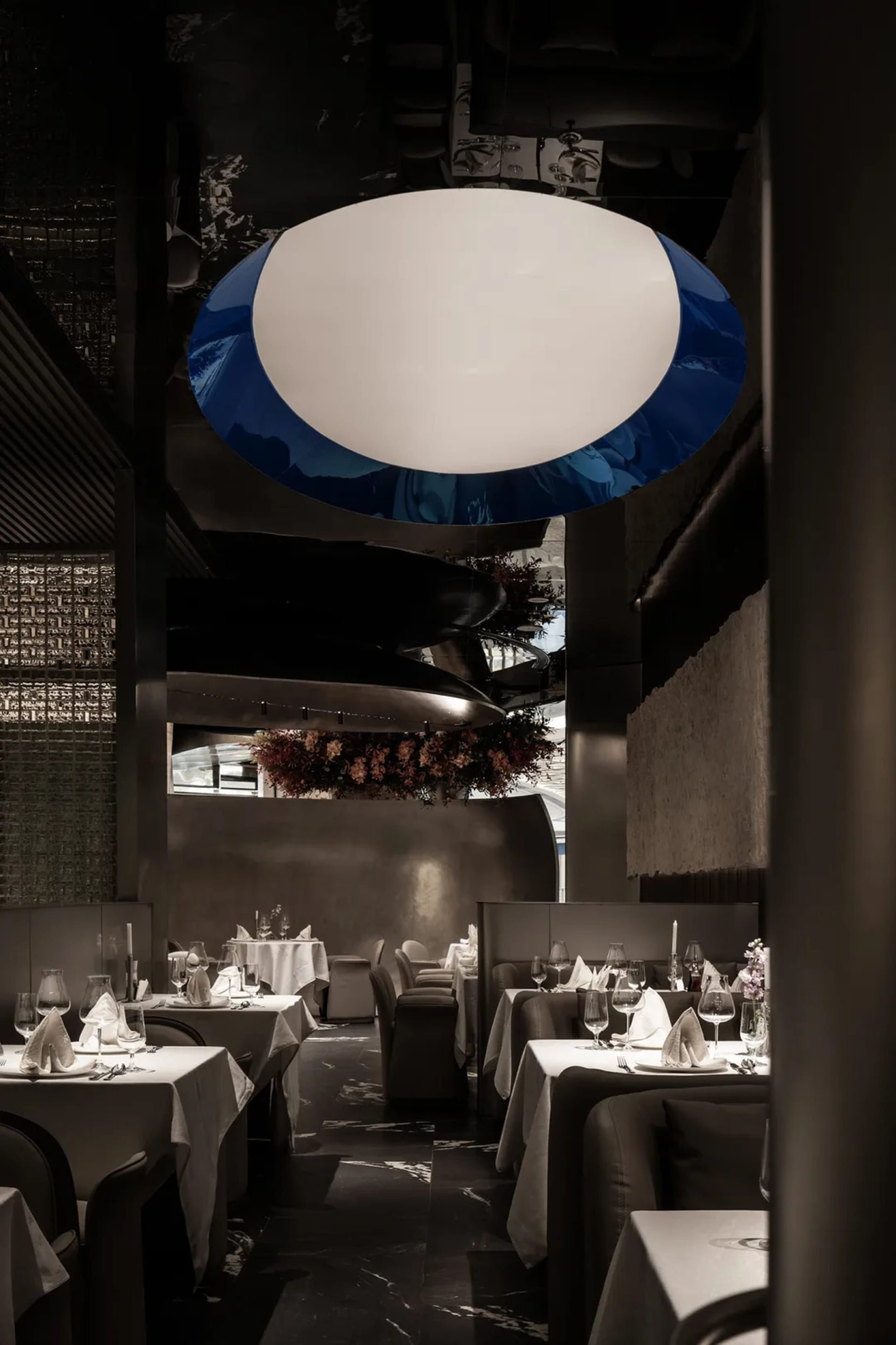 Empty restaurant with wooden tables, chairs, and wine glasses, creating an inviting atmosphere for dining