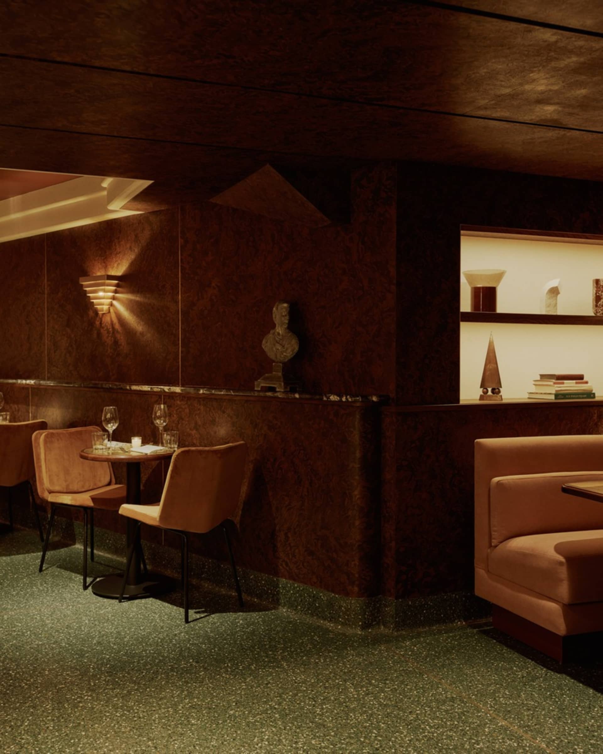 溫馨酒吧餐廳，擁有棕色牆面與地板，配有椅子、餐桌、酒杯與書籍，營造輕鬆氛圍