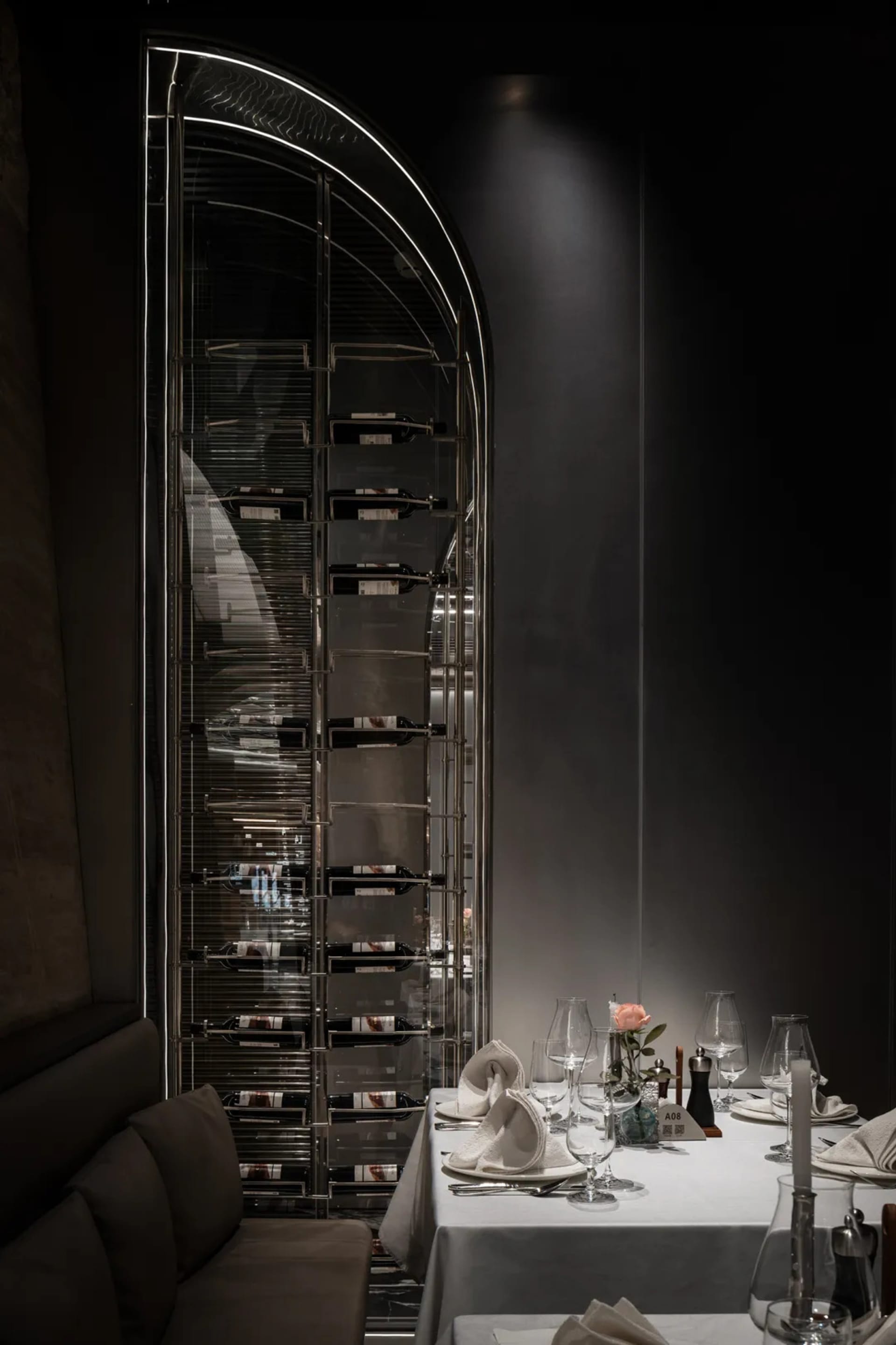 Dining area with a table set for dinner, featuring fine china, crystalware, wine glasses, and bottles, in a sophisticated and inviting atmosphere