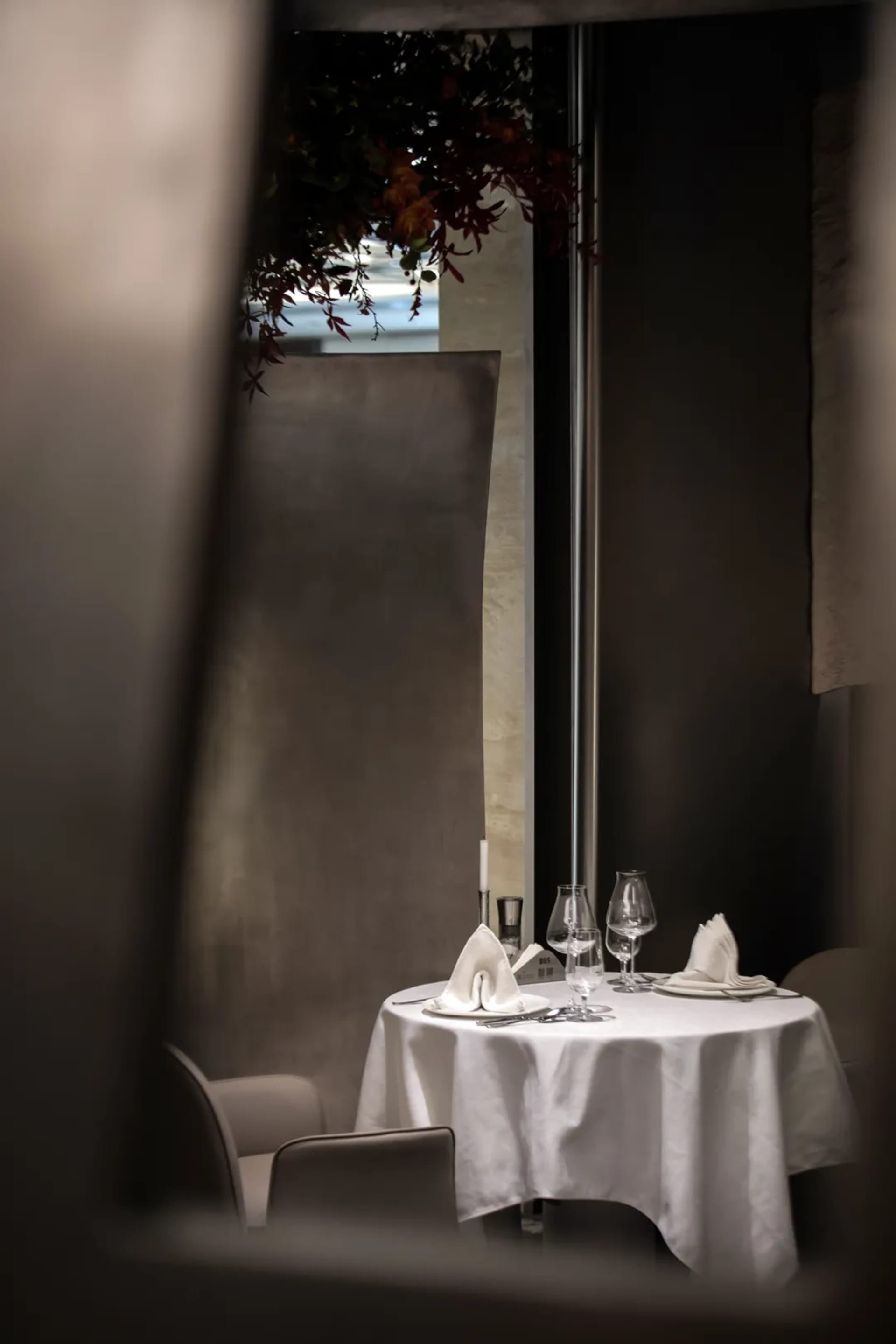 Sophisticated dining area with a white table set, wine glasses, plates, and napkins, surrounded by inviting atmosphere