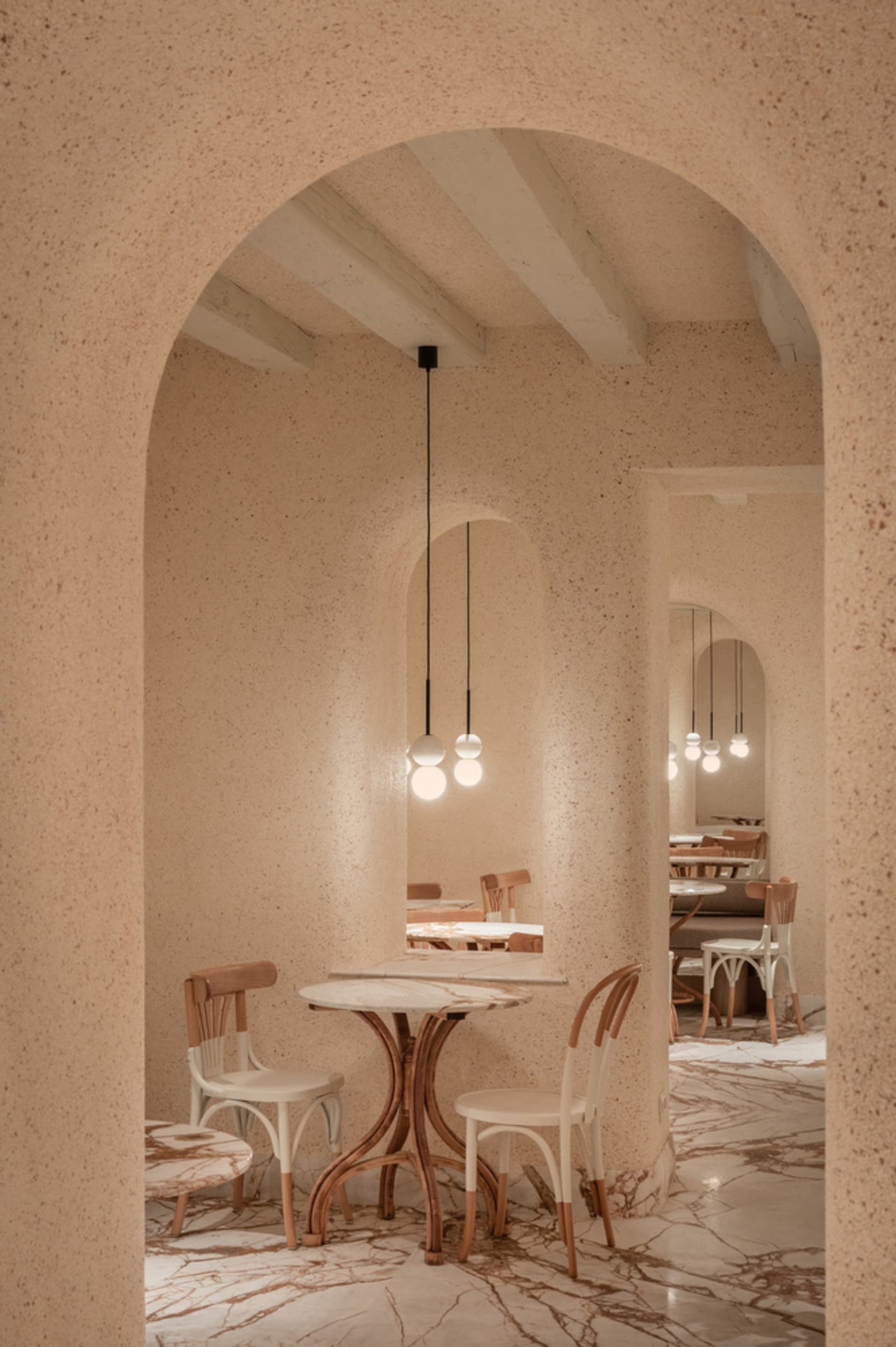 Empty restaurant interior with white tables, chairs, and lamps, creating a calm and inviting atmosphere