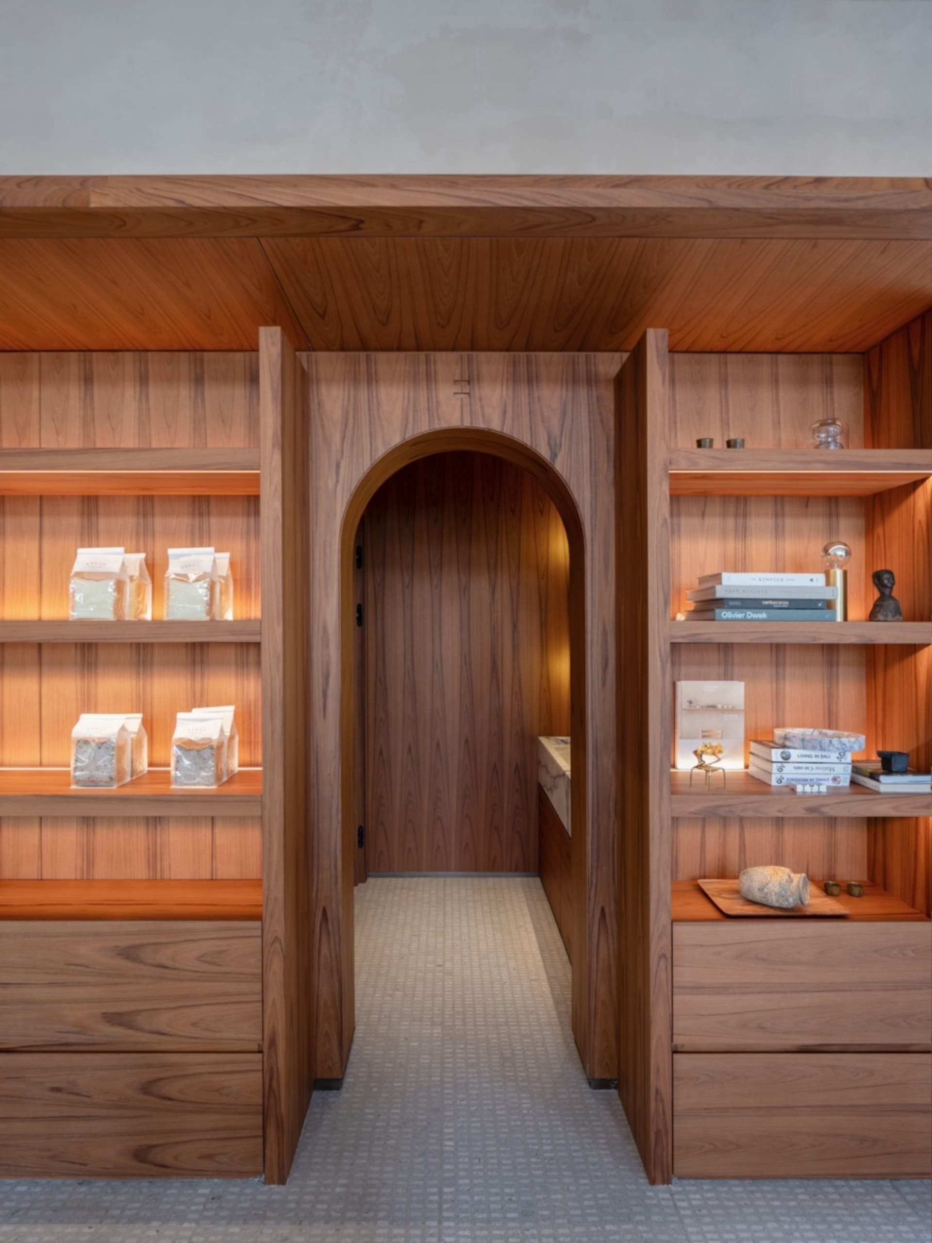 A cozy room with a wooden doorway, books, bottles, and bowls, giving a lived-in feel