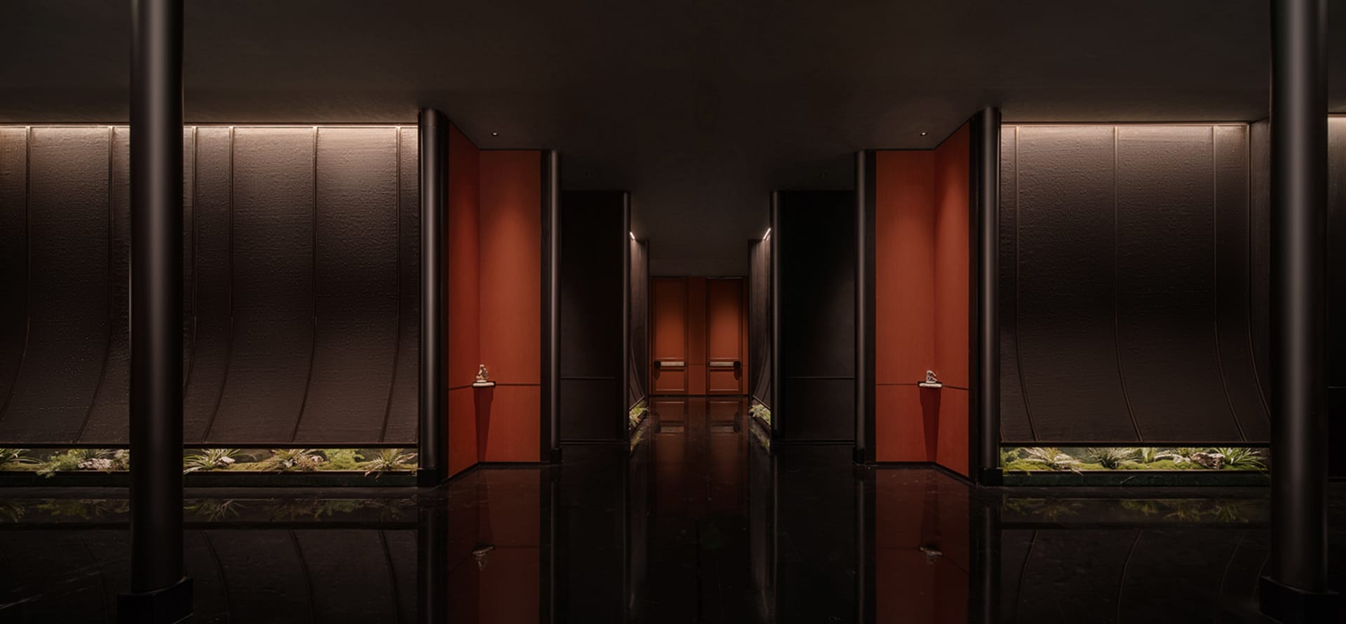 Empty office hallway with wood panelled walls, two doors, and overhead lighting