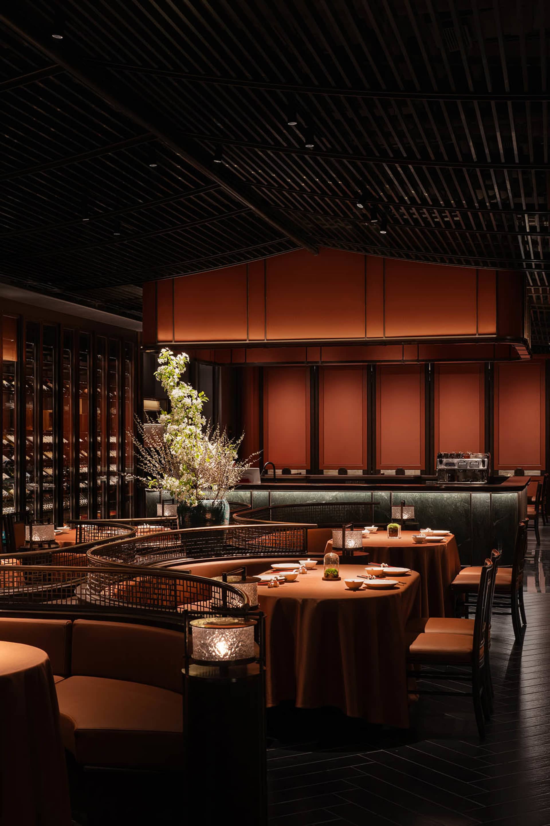 A large dining area with wood paneling, multiple tables, chairs, and wine glasses, conveying elegance and sophistication