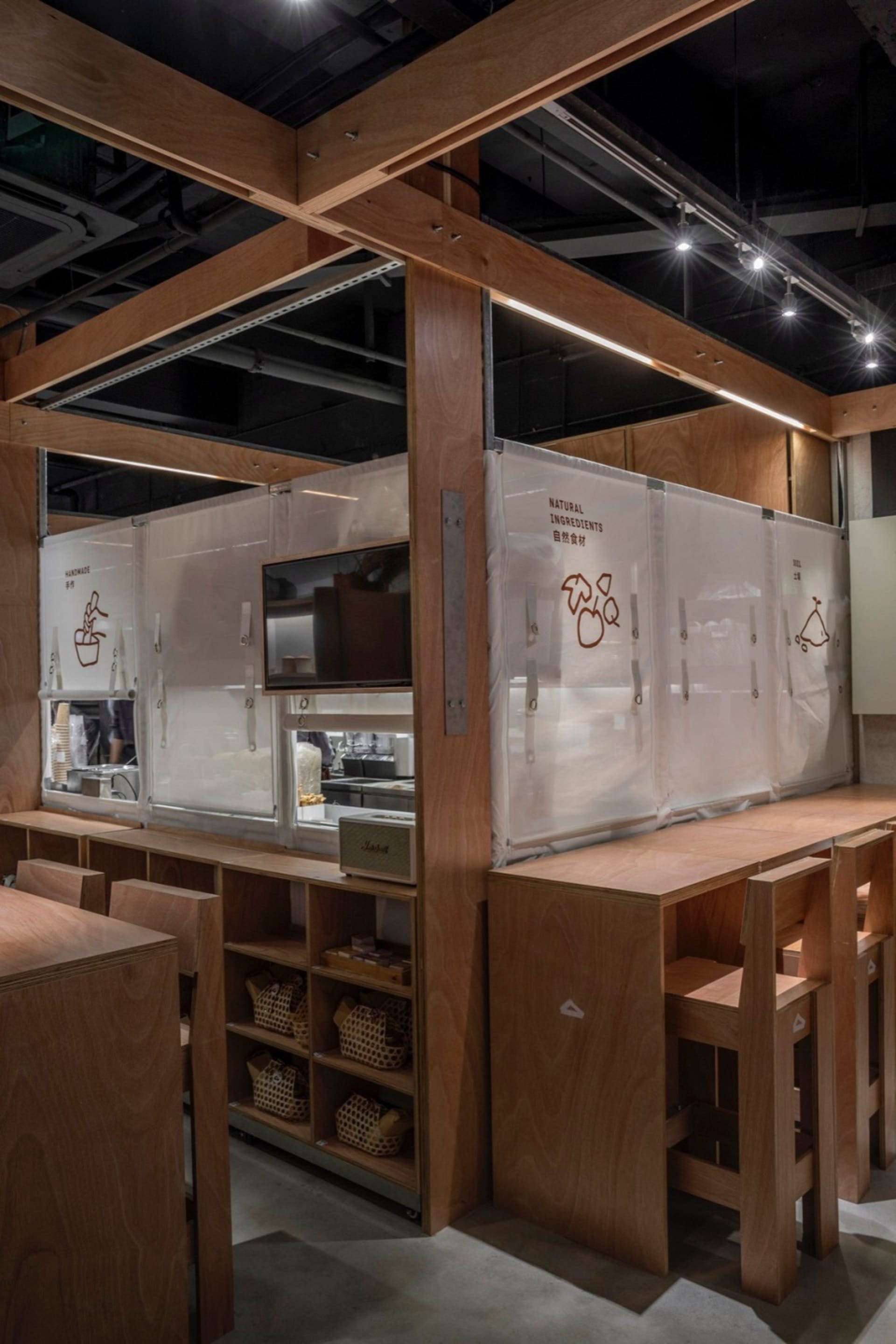 A bustling restaurant kitchen with wooden walls and floors, featuring countertops, ovens, and various kitchen items