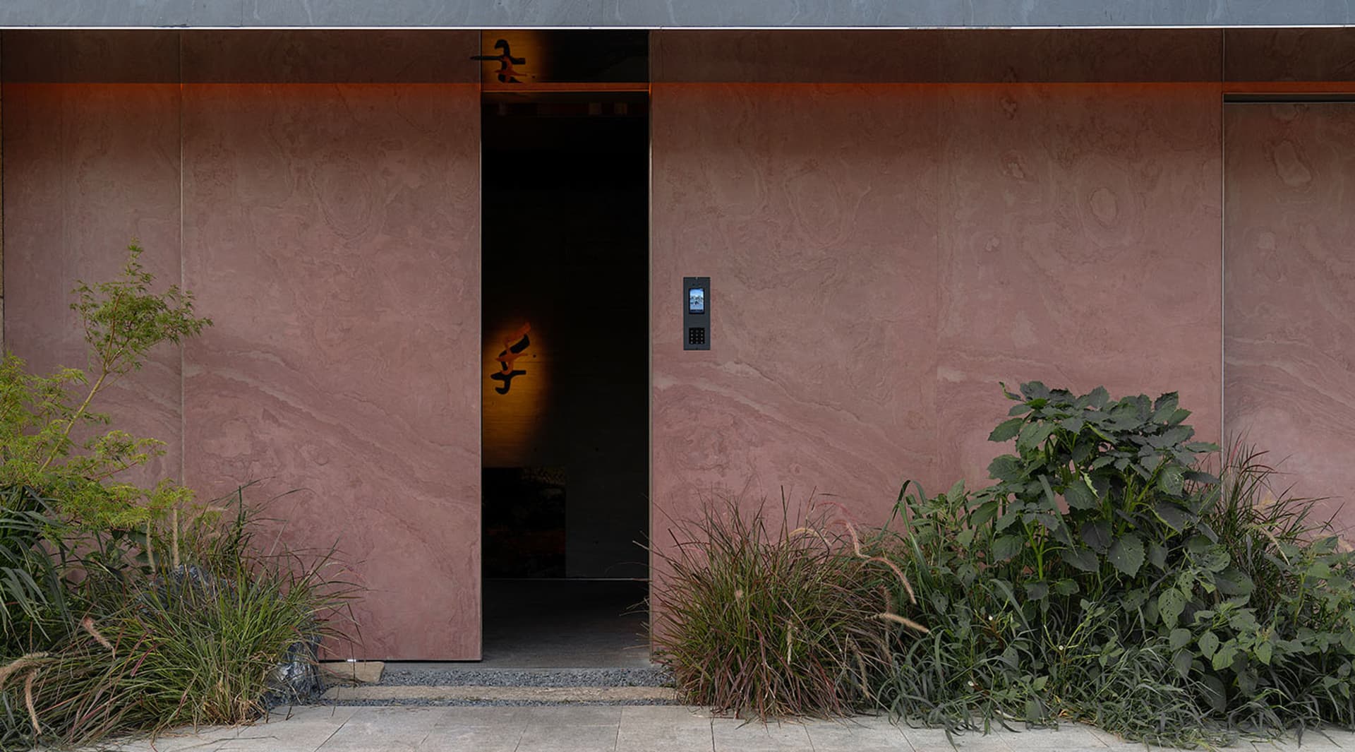 Luxurious hallway with pink marble finish, two doors, and a sophisticated atmosphere