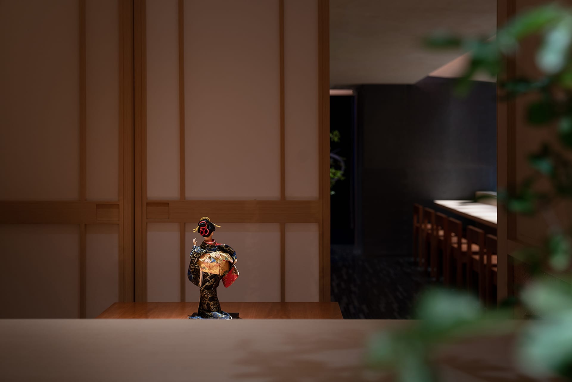 A cozy dining area with a wooden table, chairs, and a painting on the wall, creating a warm atmosphere