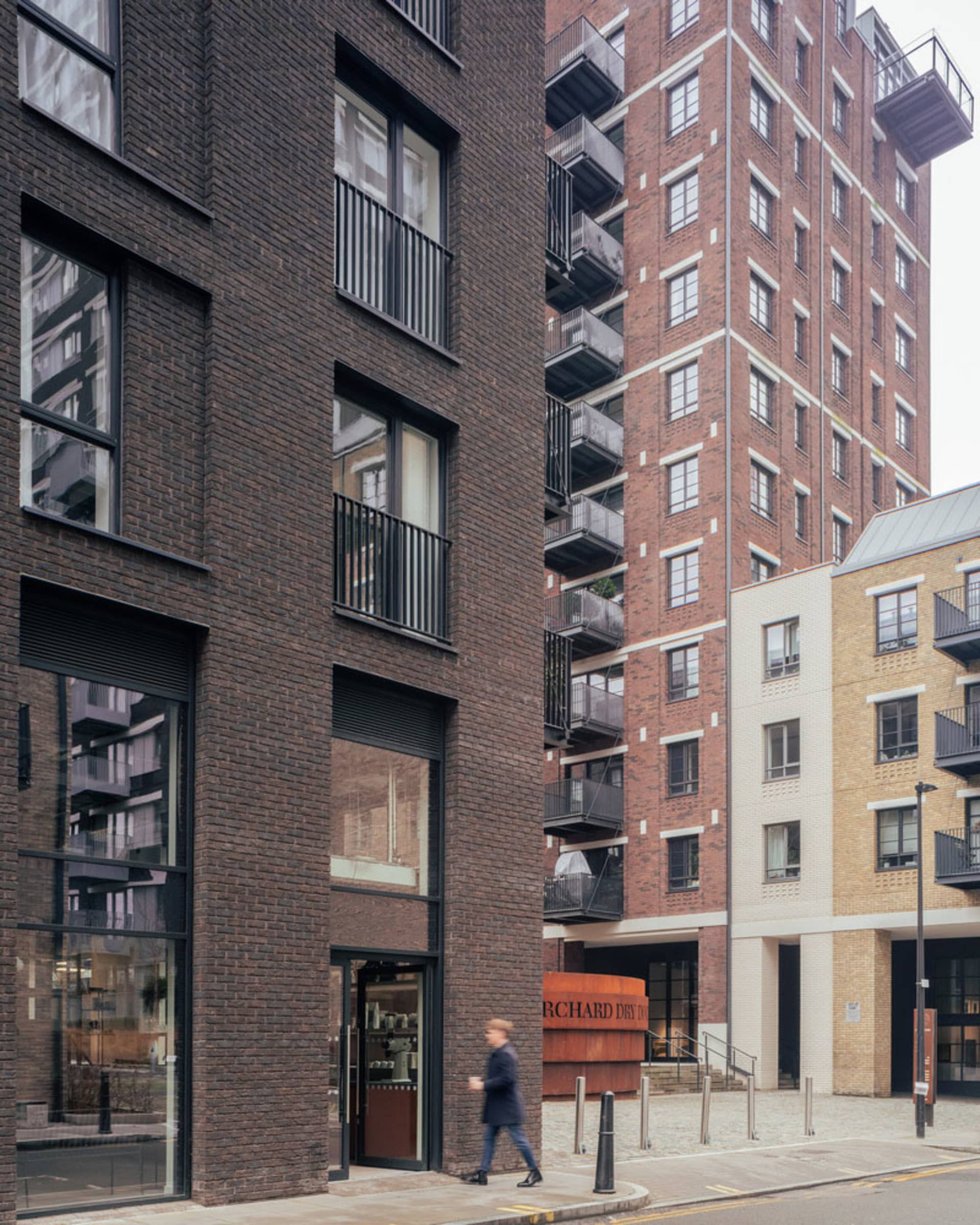 A bustling city street scene with tall brick buildings, pedestrians, and diverse architectural styles