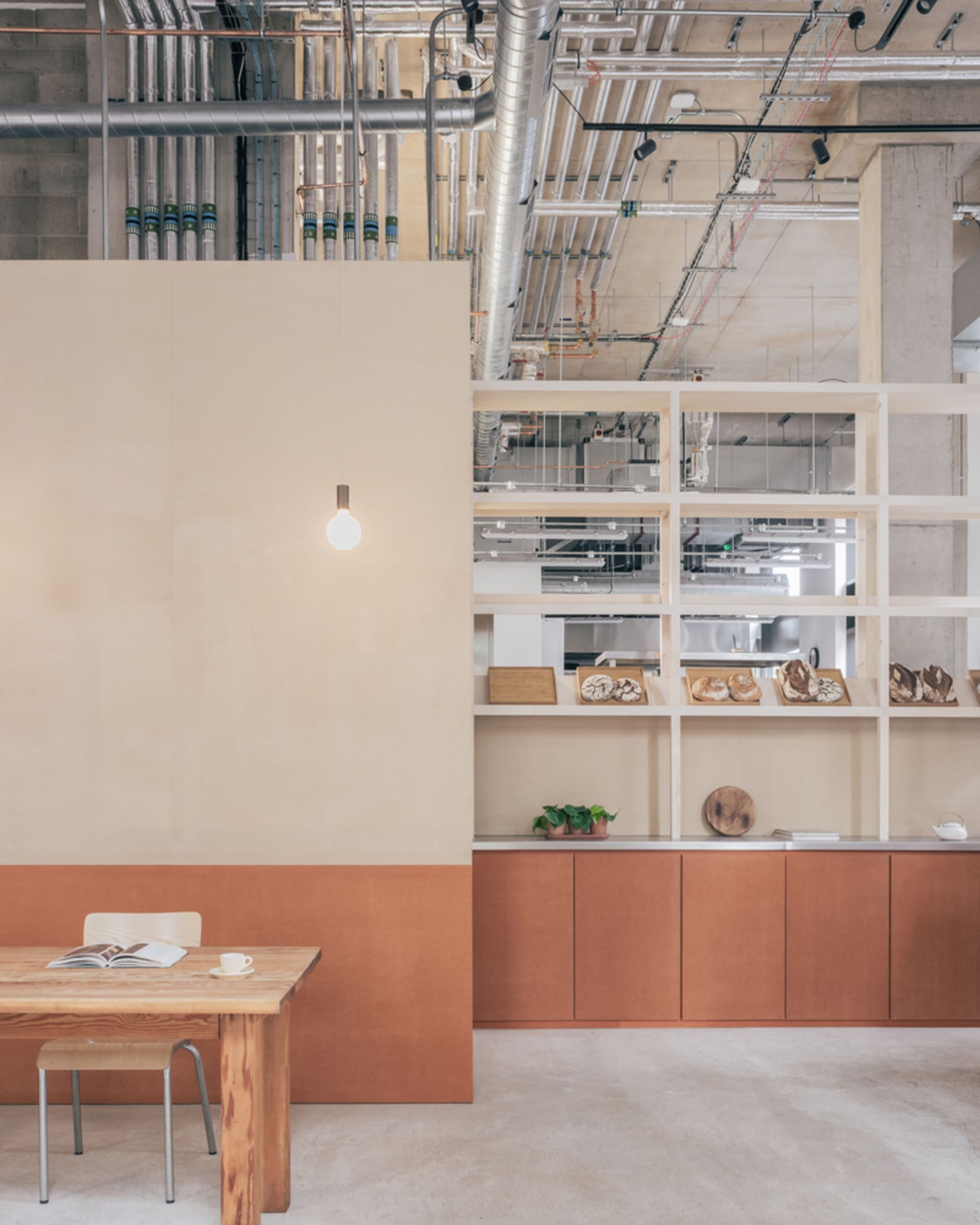 Cozy office space with wooden walls and floors, featuring two tables, a chair, a dining table, and various decorative items