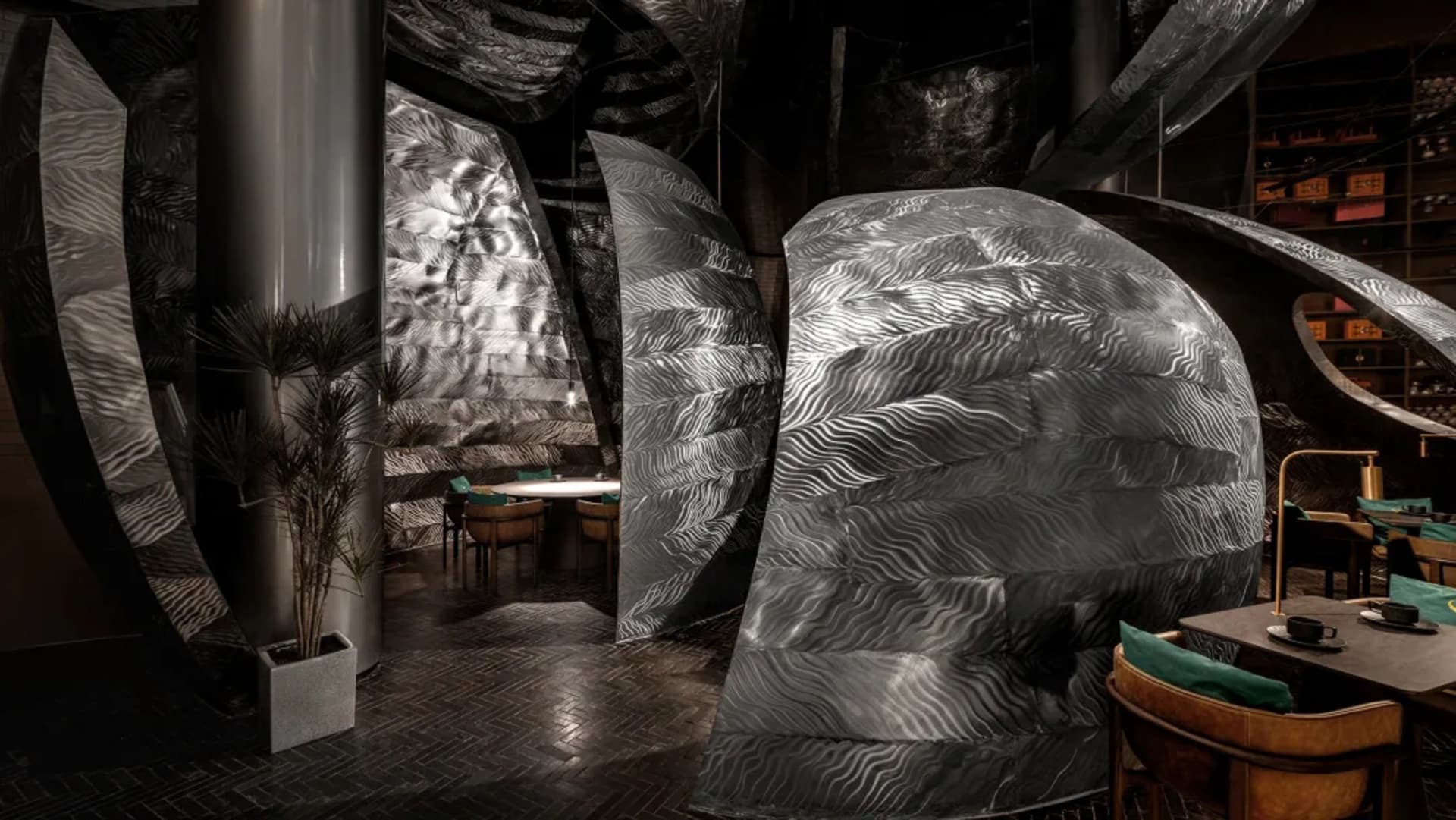Modern dining space with a metal sculpture, a dining table, and chairs in a contemporary setting