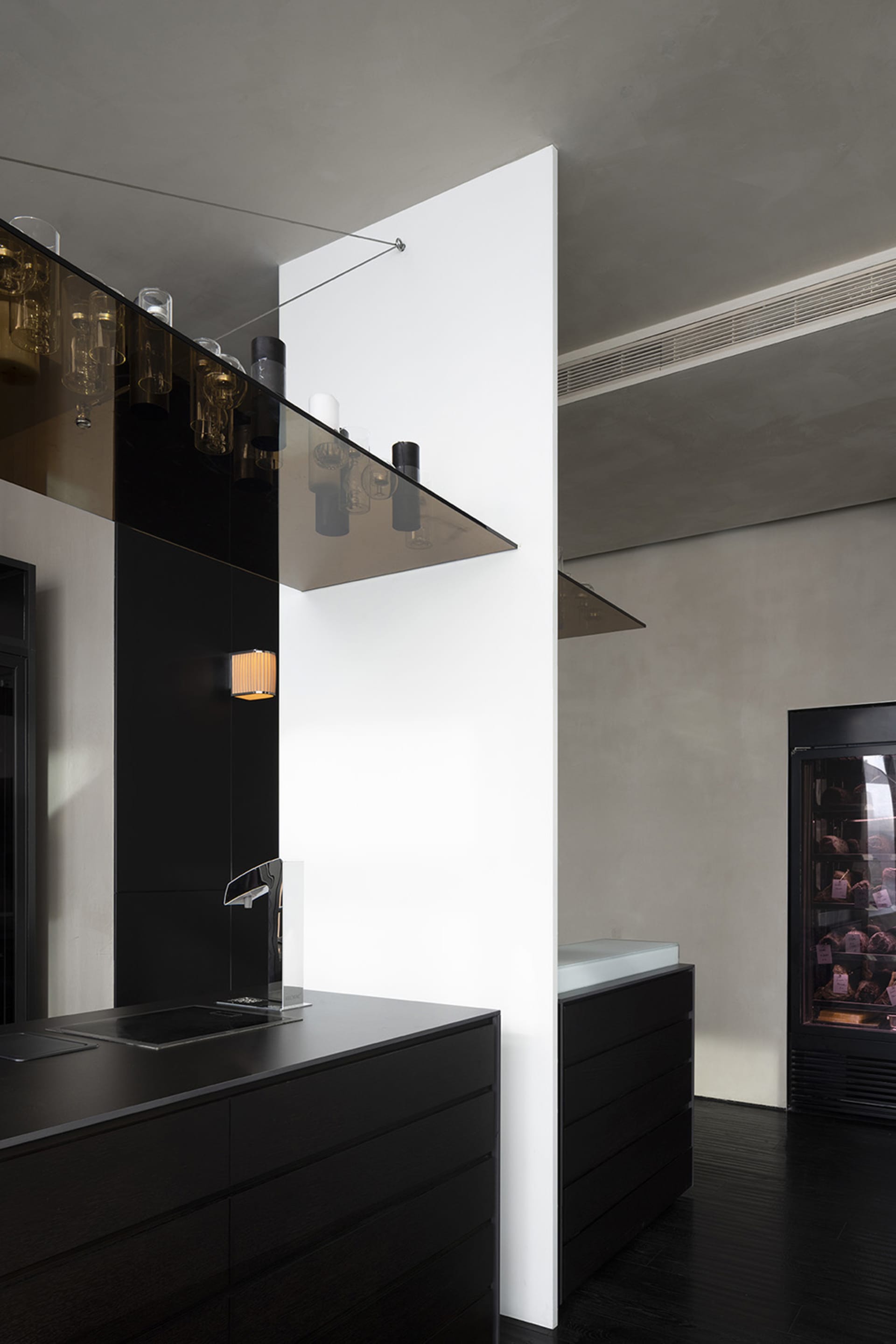 Modern kitchen with black cabinets, a sink, and dining area with a table and chairs, wine glasses, and a sleek design