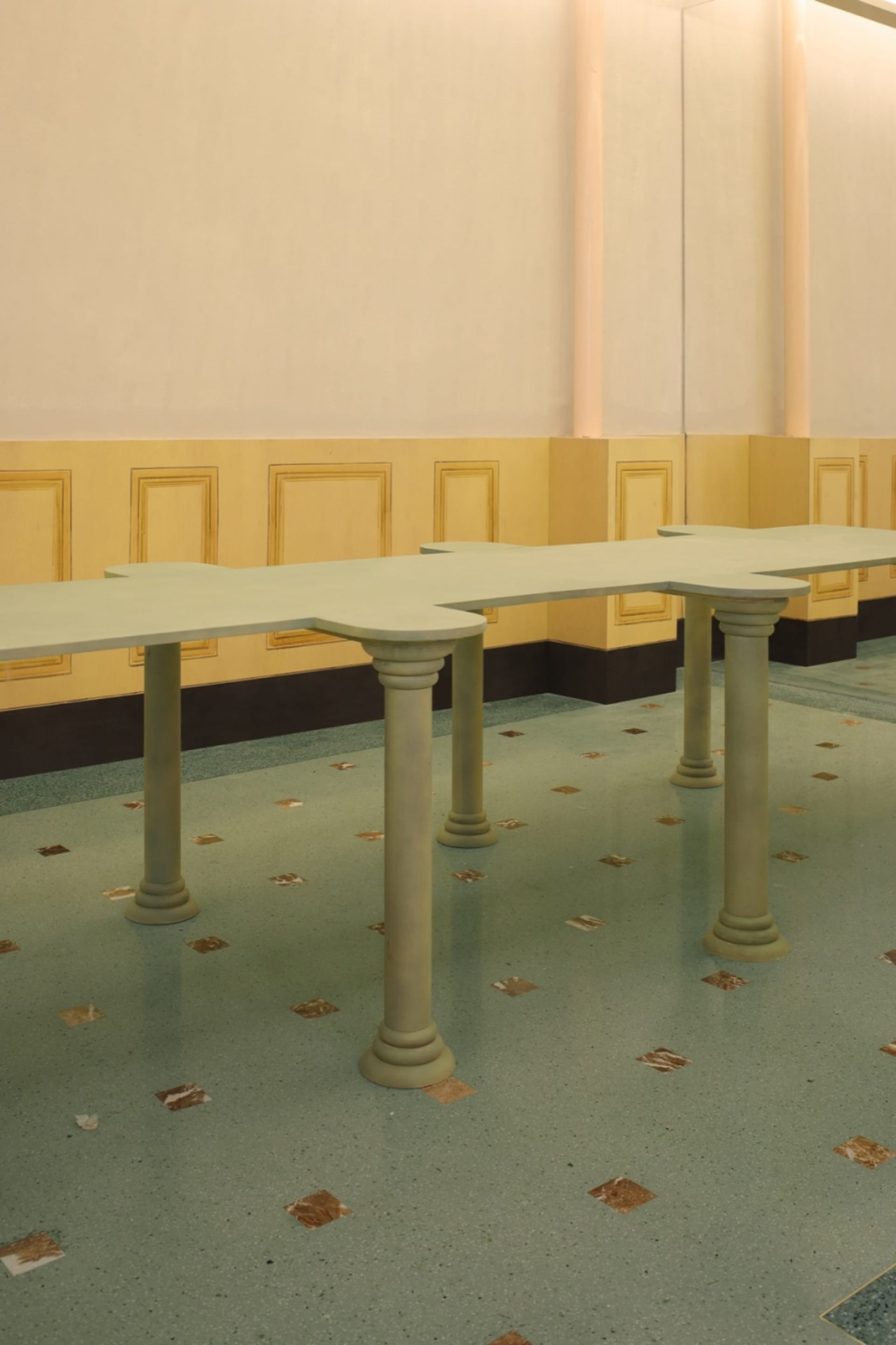 A spacious room with two tables and four chairs on a tiled floor, suggesting a formal gathering or event