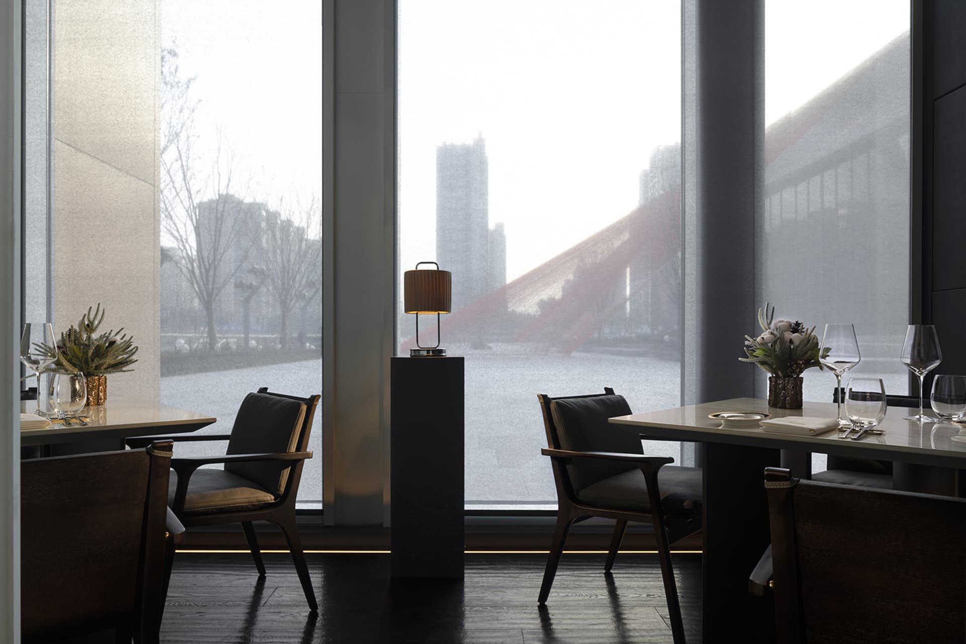 A bright and inviting restaurant interior with glass walls, modern furniture, and natural light from large windows