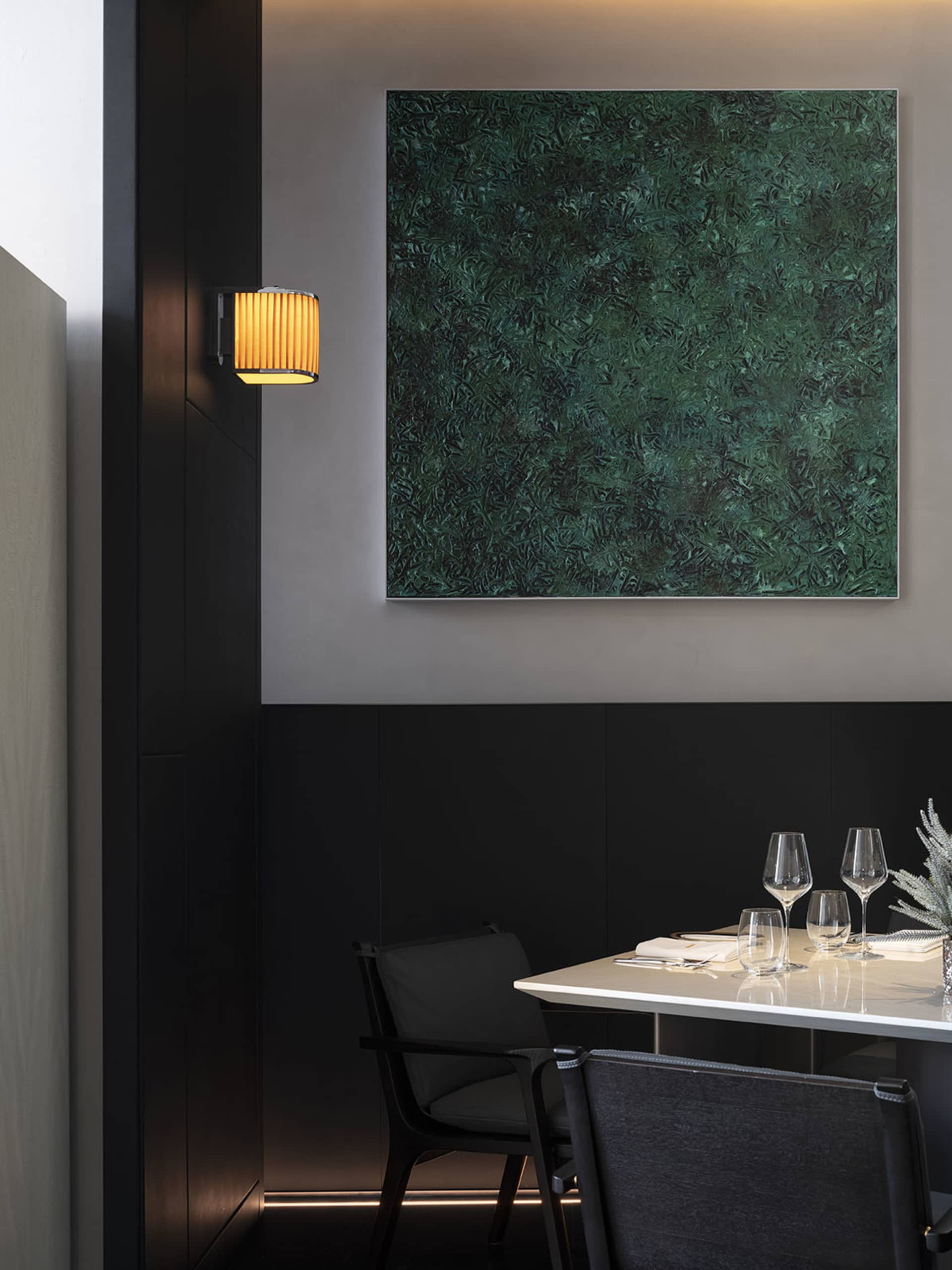 Elegant dining space with a dark wood table and chairs, glassware, and fine china, set in a sophisticated atmosphere