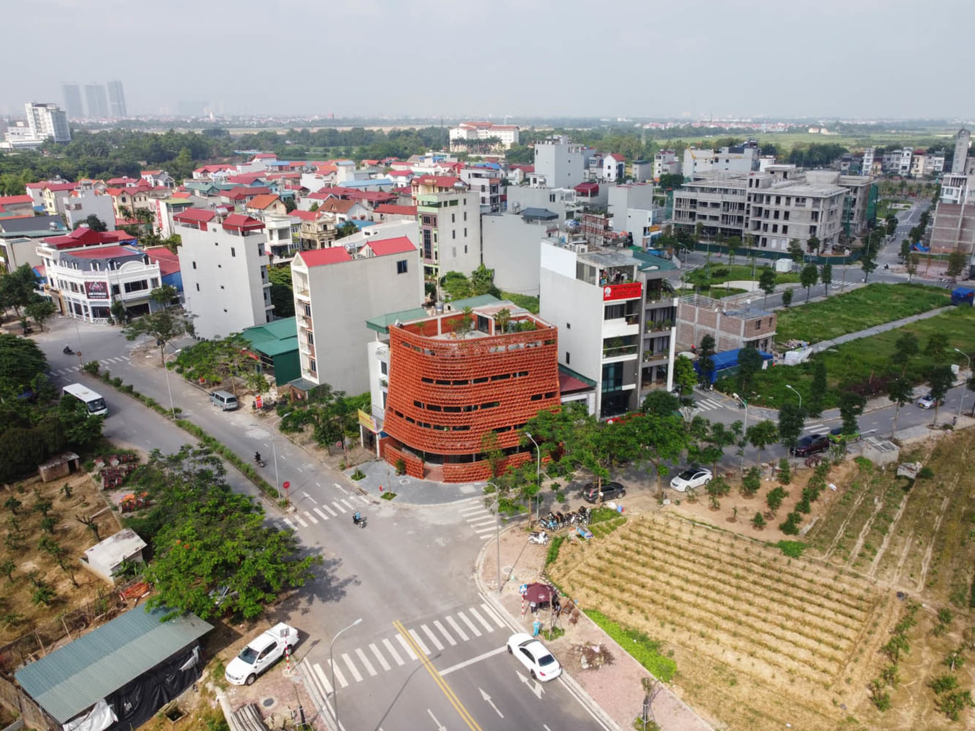 A bustling city street with tall buildings, cars, trucks, and pedestrians navigating the urban environment