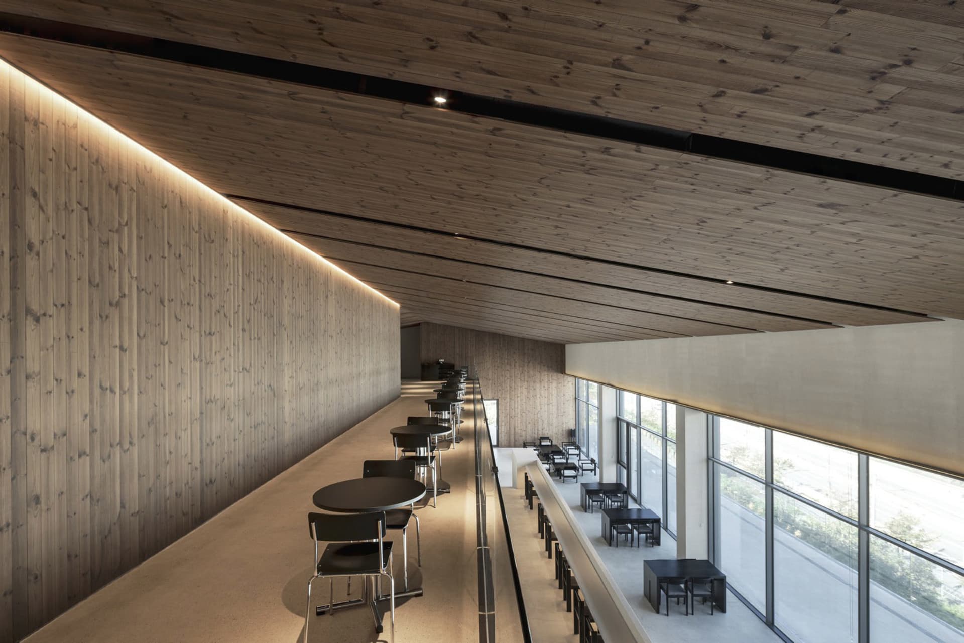 Dining area with wooden walls, tables, and chairs, creating a warm and inviting space for guests