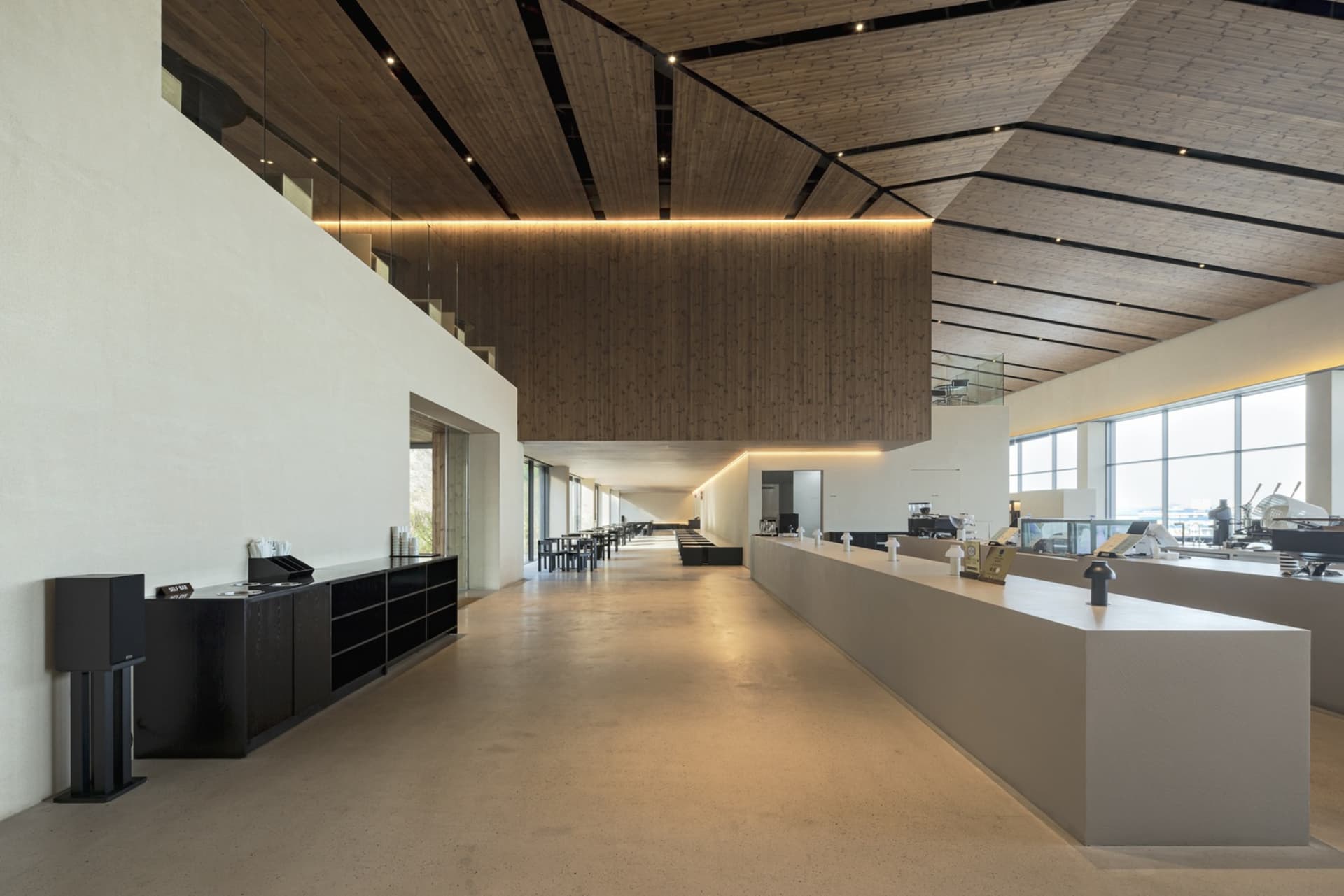 Spacious lobby with wooden walls and ceiling, modern design, wood and concrete elements, chairs, inviting atmosphere